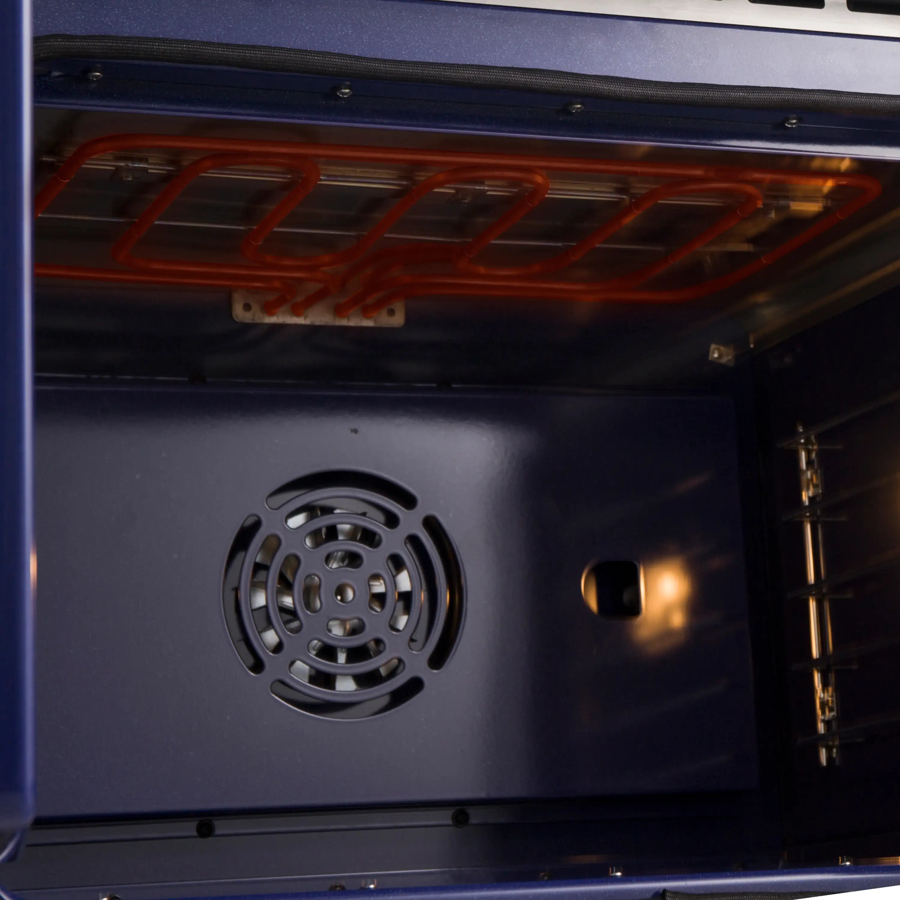 Interior view showing fan vent and glowing heating elements above oven cavity