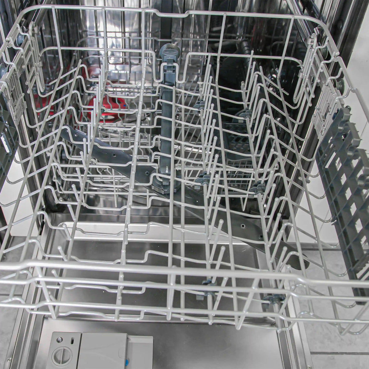 Dishwasher interior with upper rack and silver wire tines