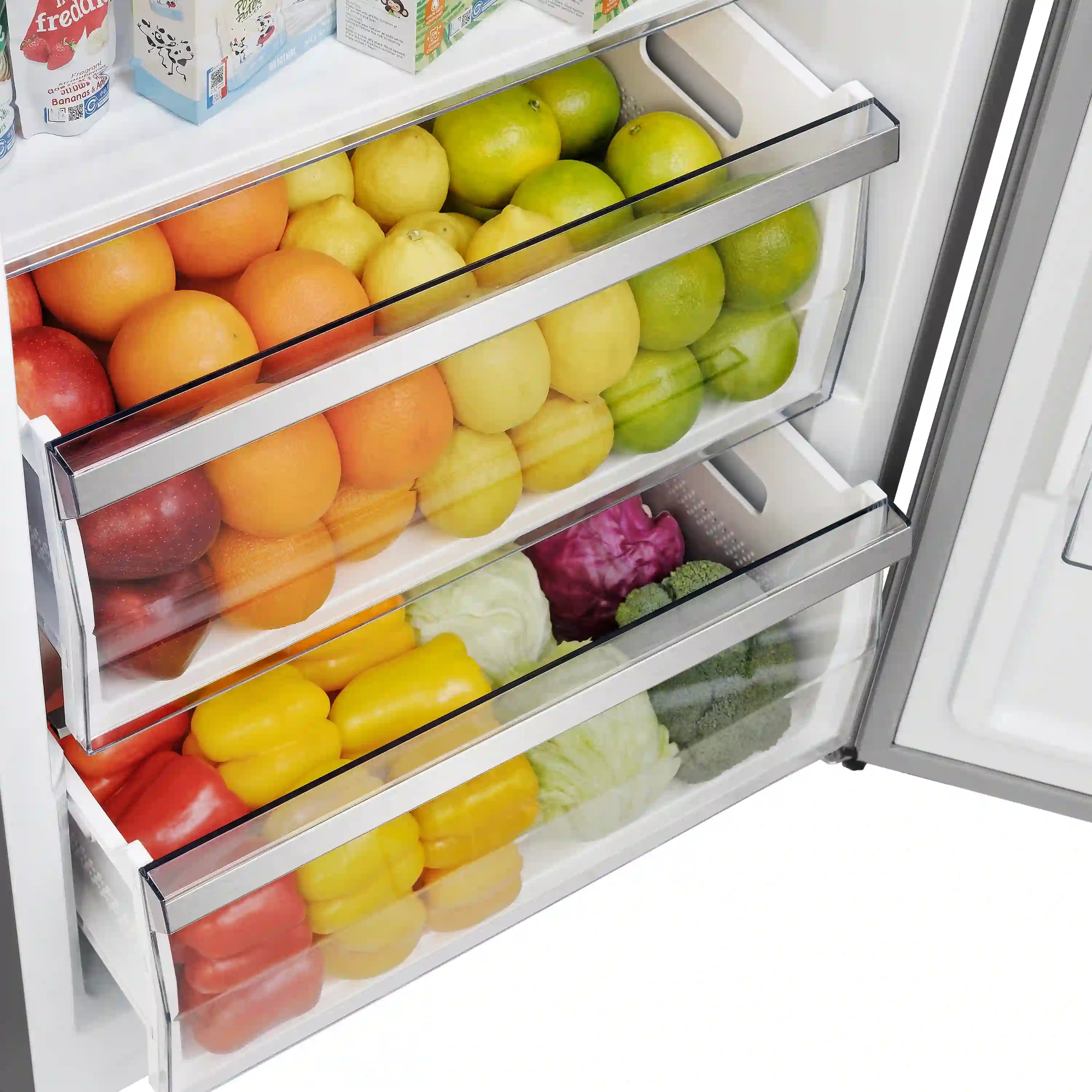 Refrigerator interior with two produce drawers filled with assorted apples and lemons.