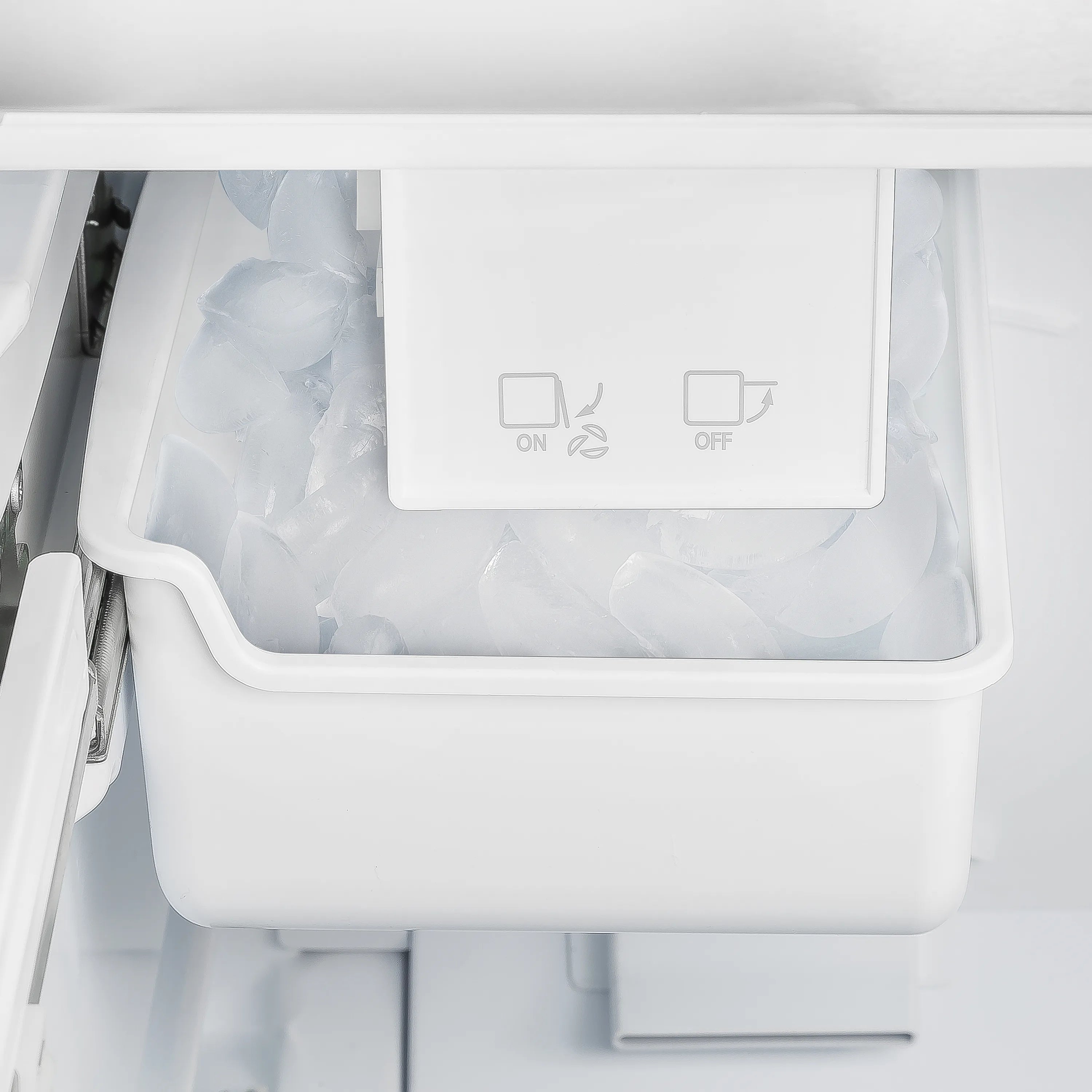 Refrigerator ice bin with ice cubes and control icons on the interior panel
