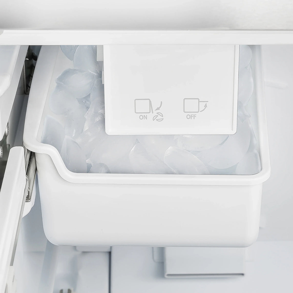 Refrigerator ice maker bin area with ON/OFF controls and white internal housing