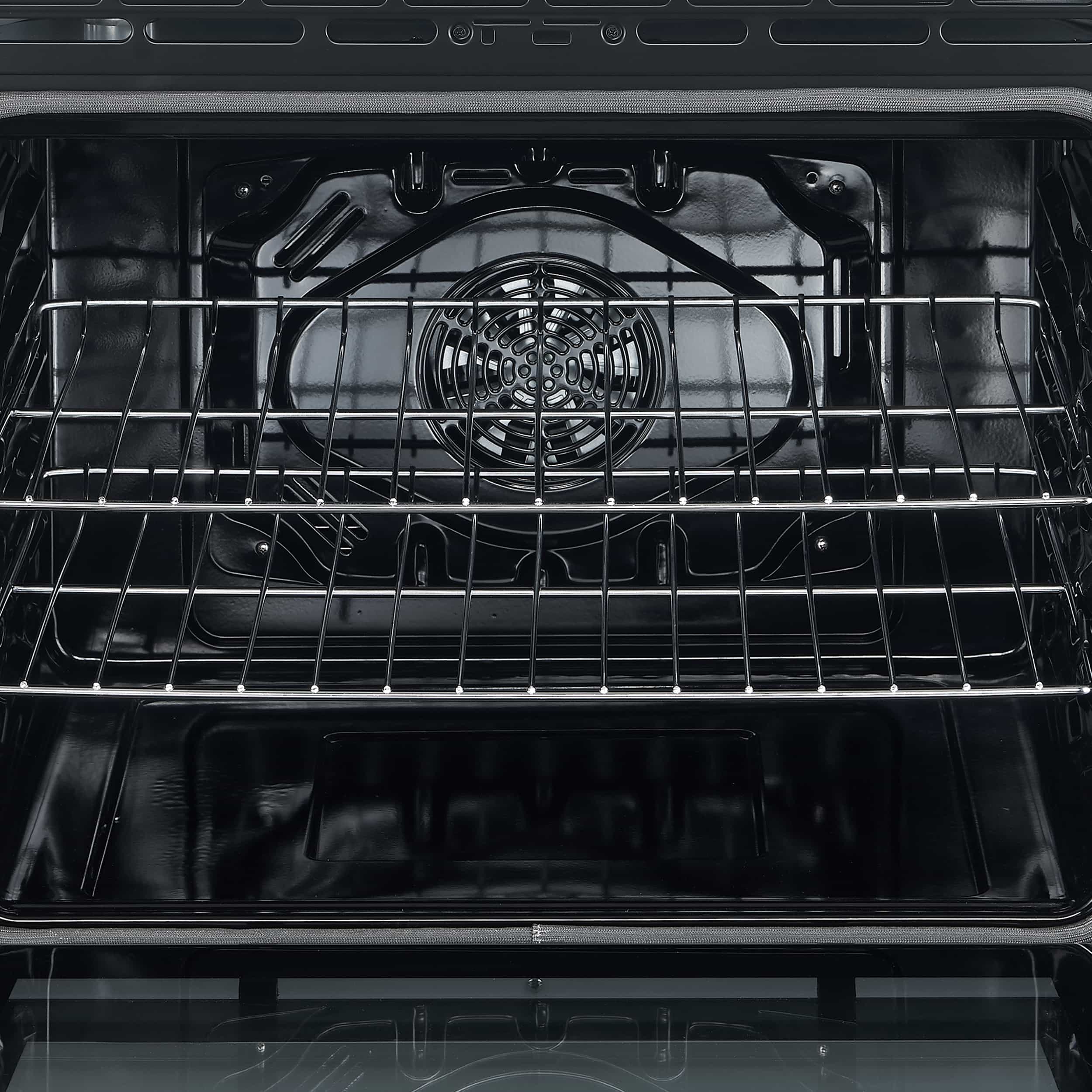 Electric range oven cavity close-up with fan, metal racks, and bake surface grid