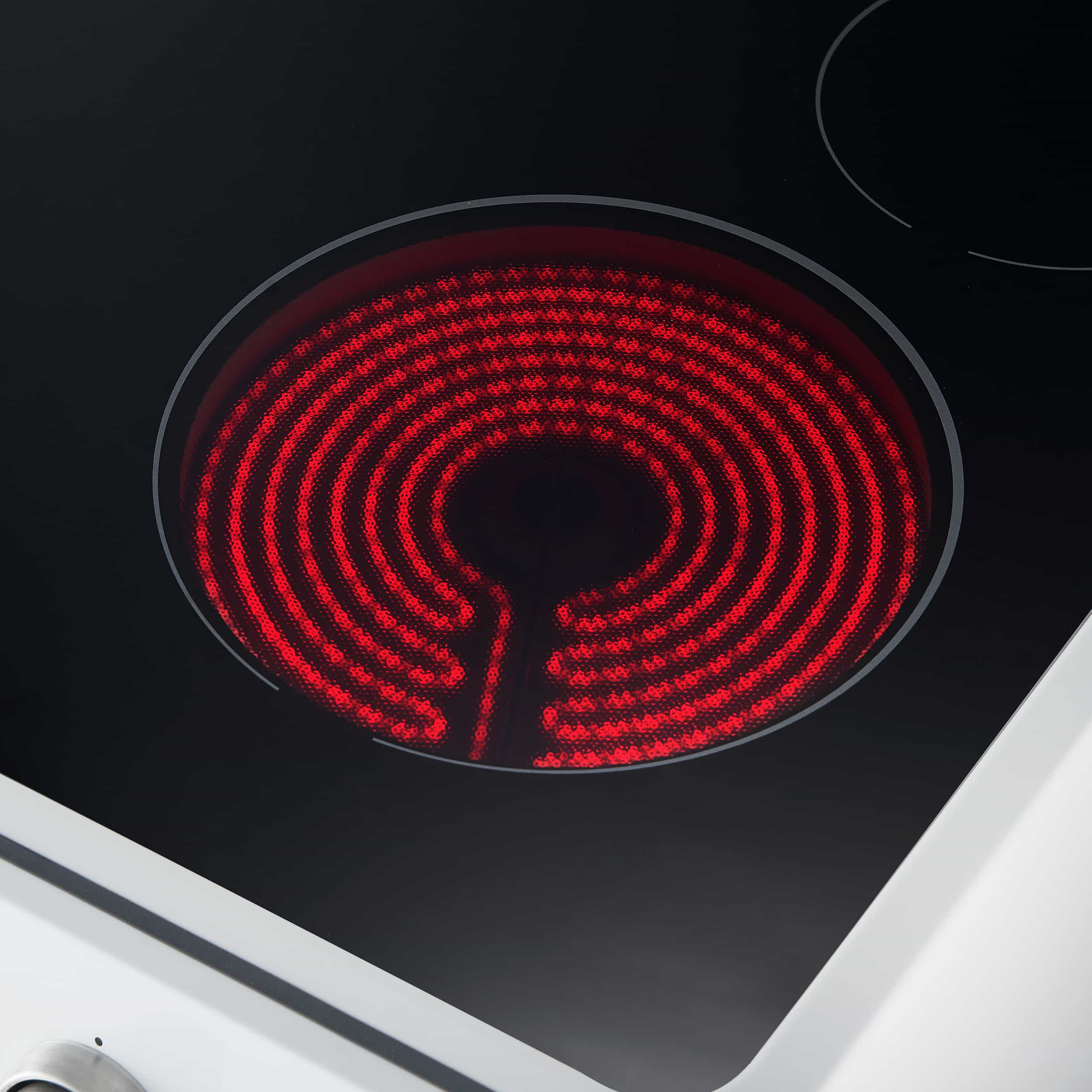 Red glowing electric cooktop coil on a black glass surface