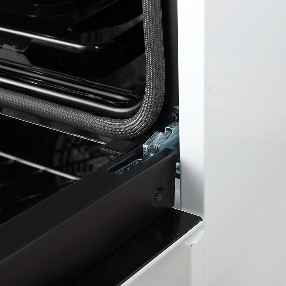 Oven door hinge and side vent opening on a white gas range