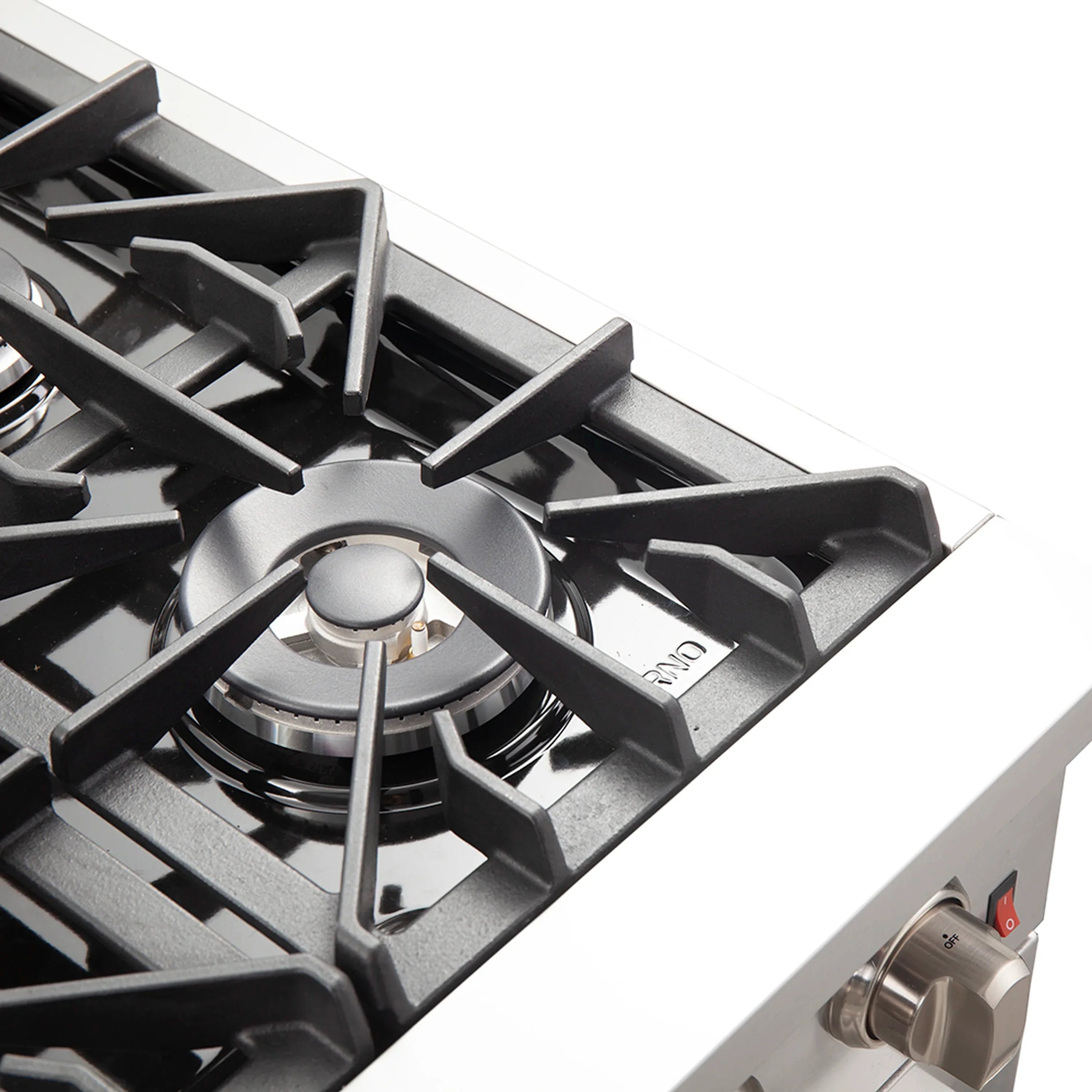 Gas cooktop control knob and black grate over lit burner