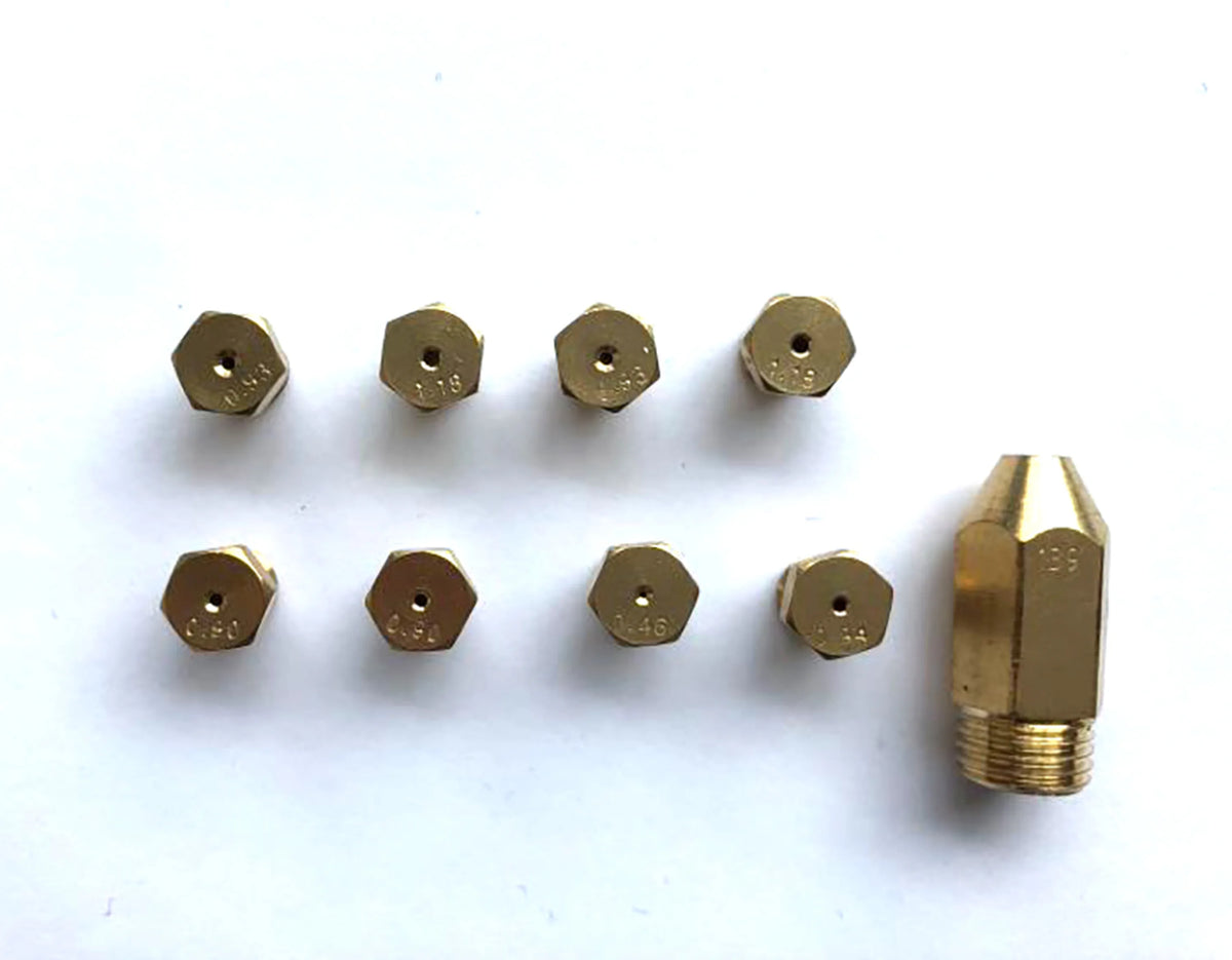 Gas range burner caps and brass-colored nozzle tips with matching fittings