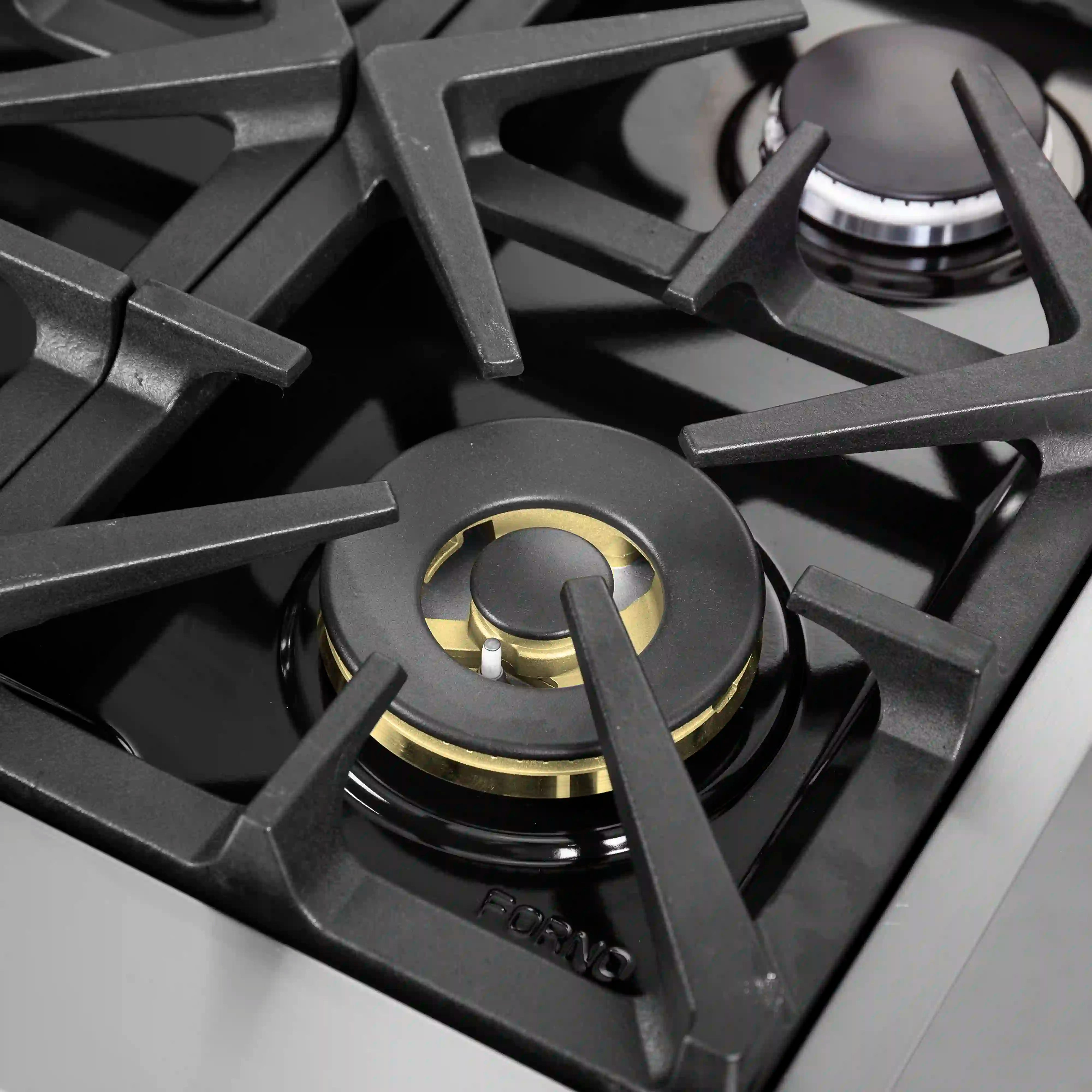 Black gas cooktop burner with brass-accent control knob