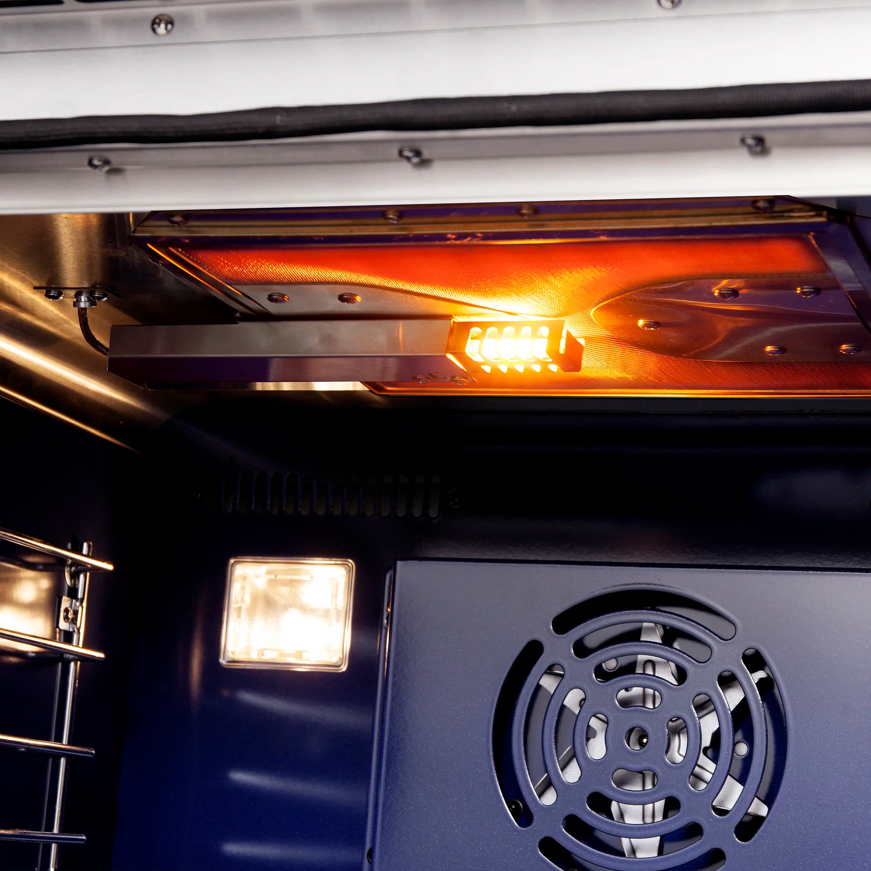 French door gas oven interior with lit heating elements and rear fan