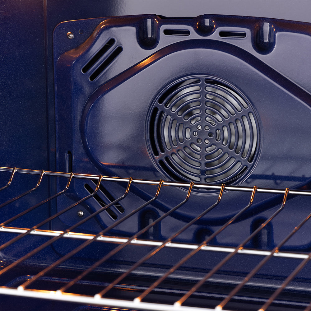Black oven cavity with wire rack and round convection fan, brass trim visible