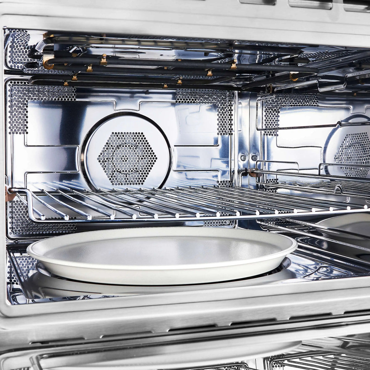 Dual fuel range oven interior with wire racks and round baking pan