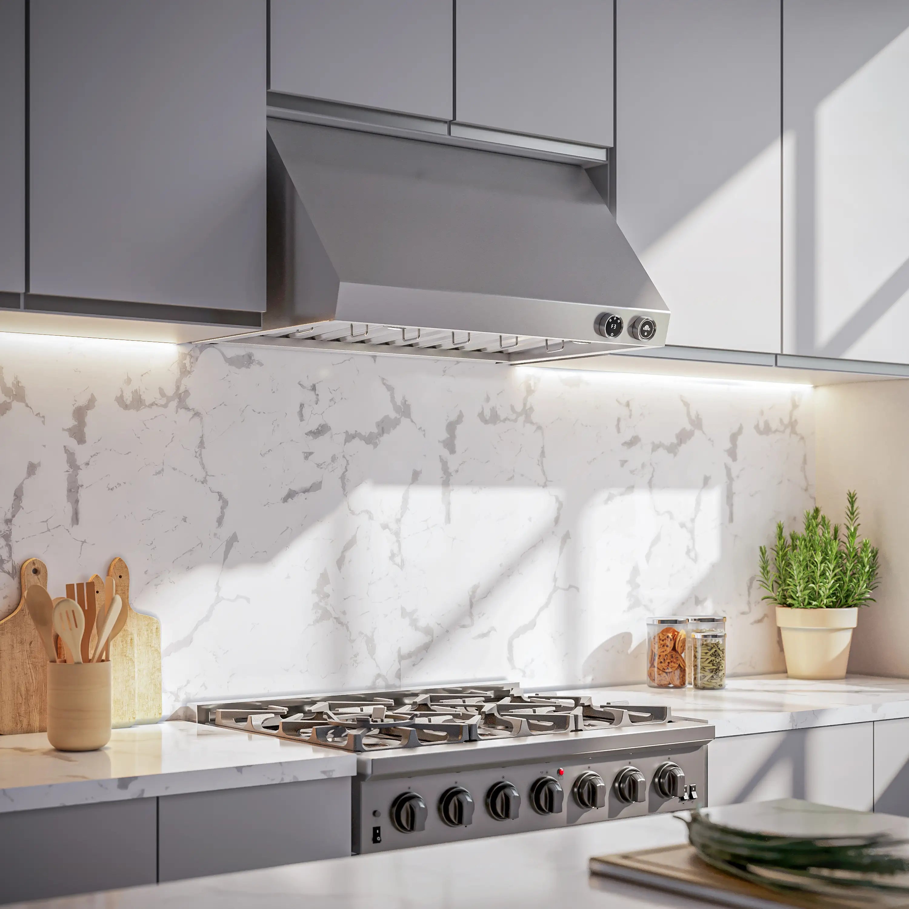 Installed stainless under-cabinet range hood above cooktop with control knobs