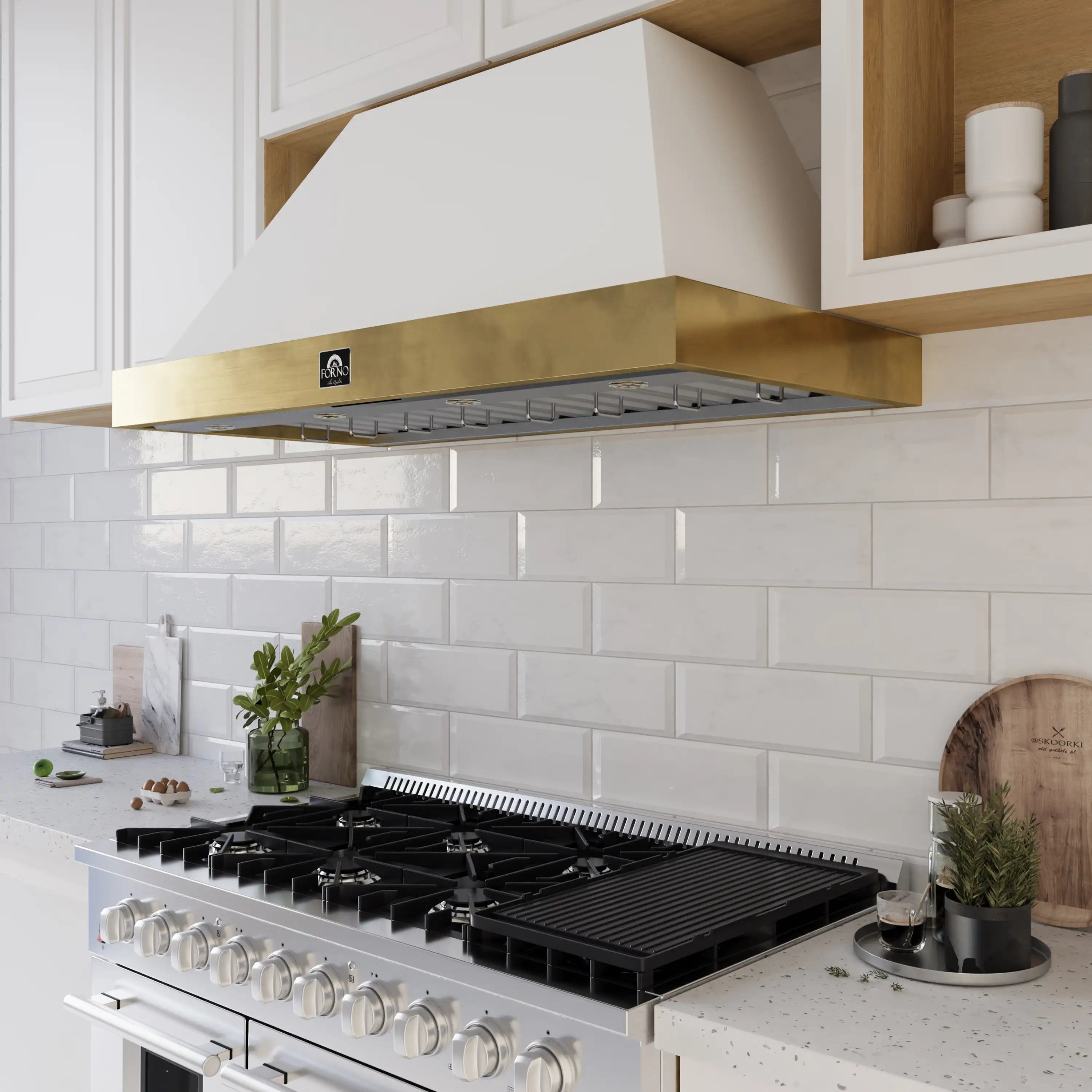 White wall-mount range hood with antique brass trim over gas cooktop canopy