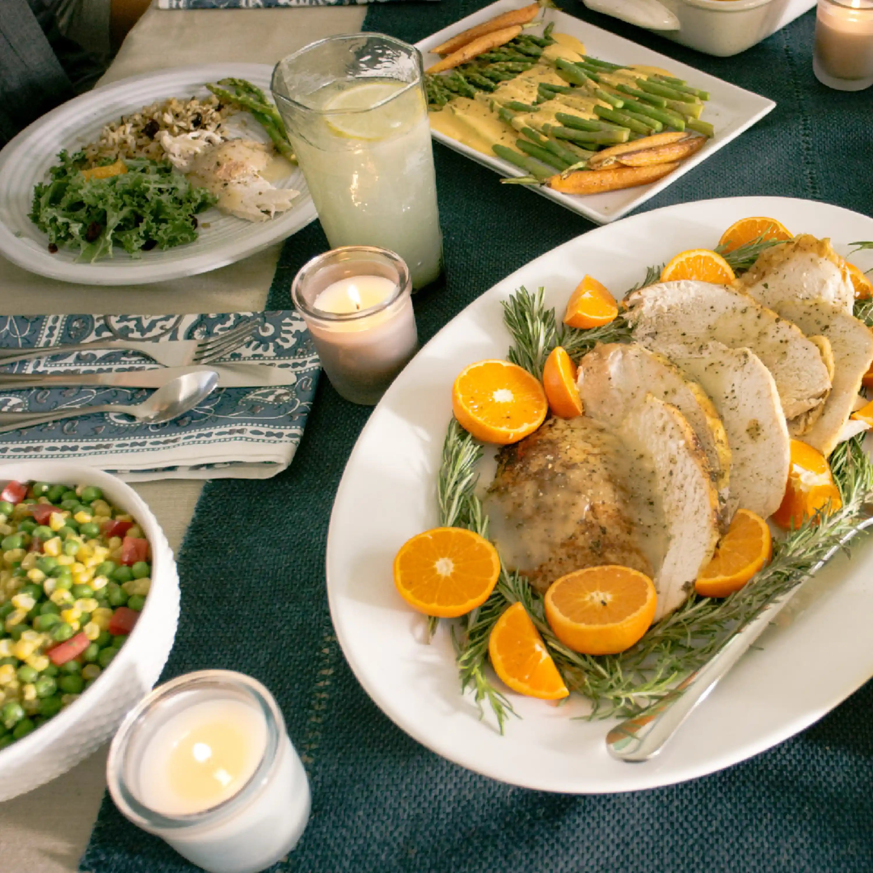 Plated rehydrated meal with chicken, orange slices, asparagus, and green peas side