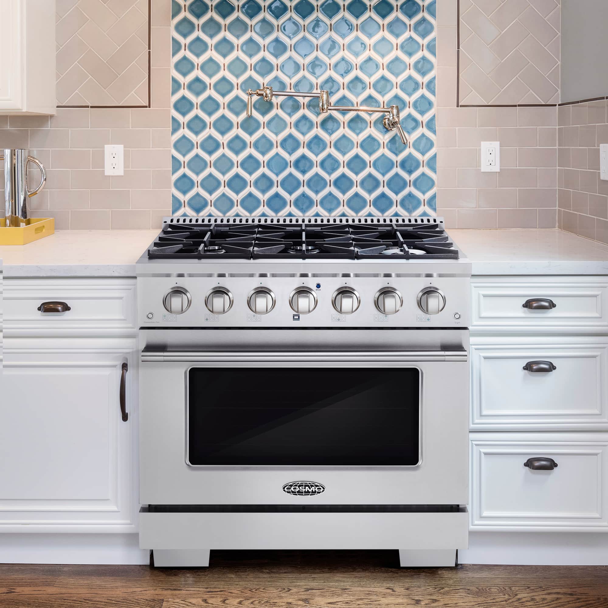 Stainless gas range centered in white kitchen cabinets with black oven window and burners