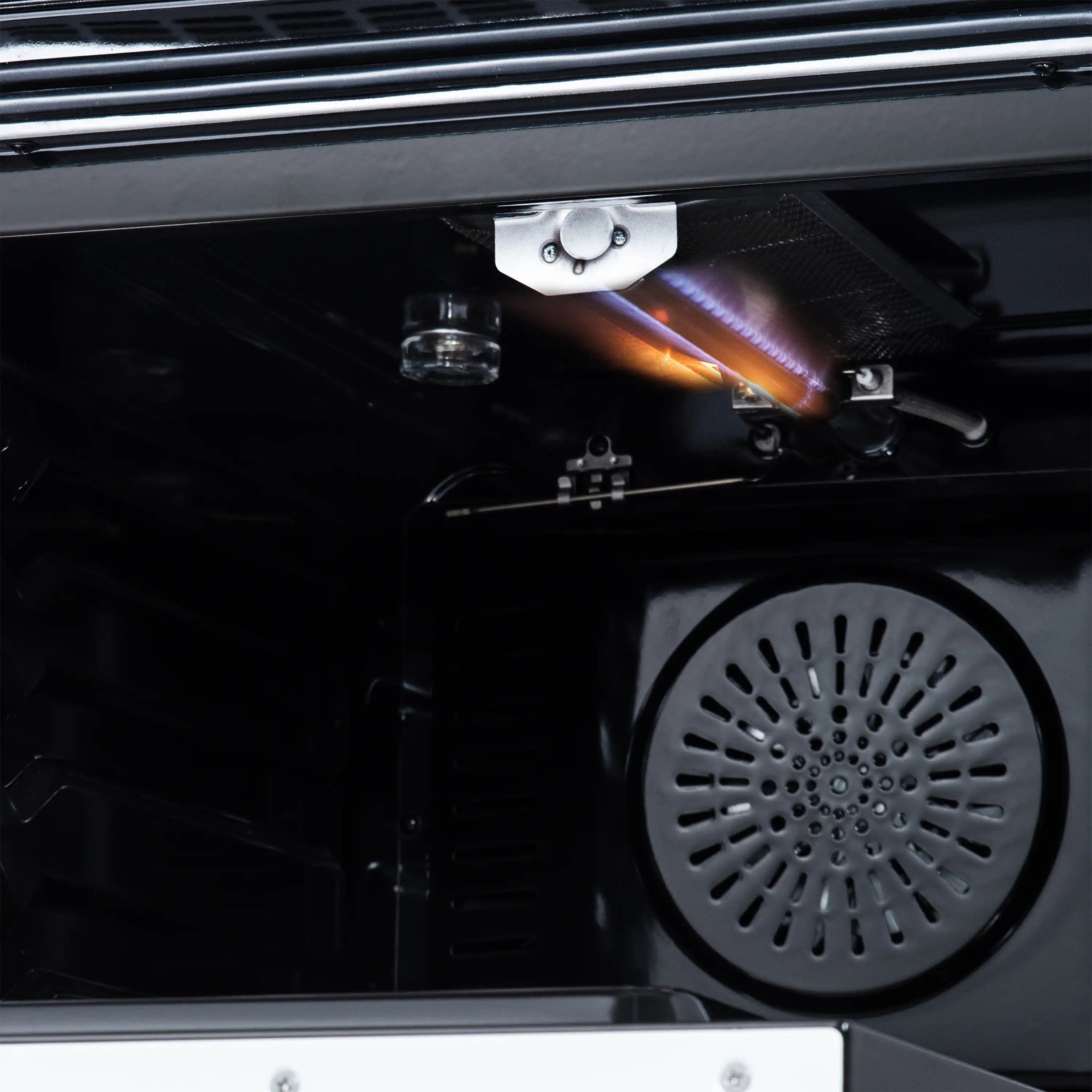 Close-up of oven interior with broiler igniter and convection fan grille