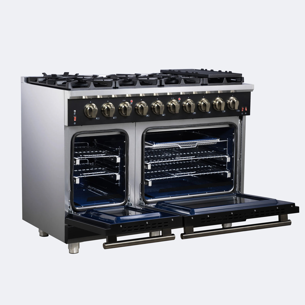 Black freestanding gas range with open double ovens, brass-toned knobs, and burner grates
