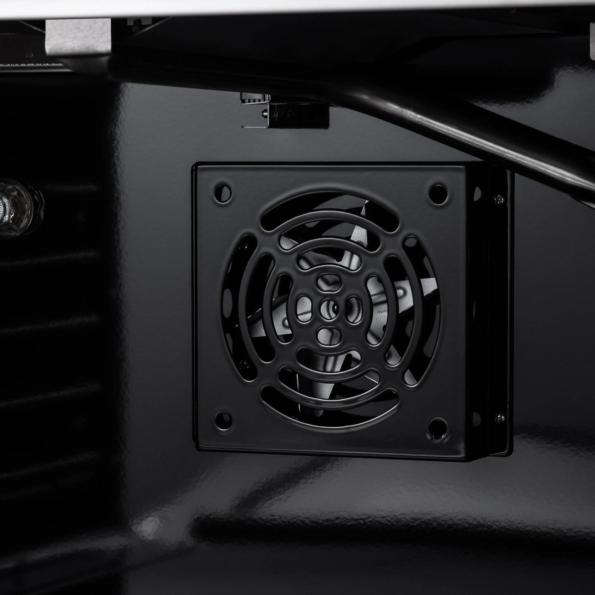 Close-up of oven vent fan grille inside dark oven cavity