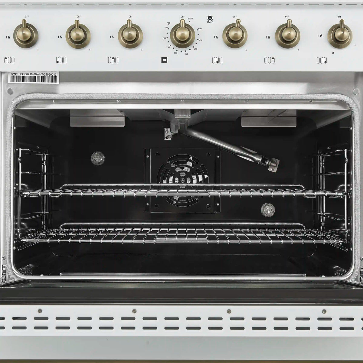 Dual fuel range oven interior with metal racks, bake element, and fan at back