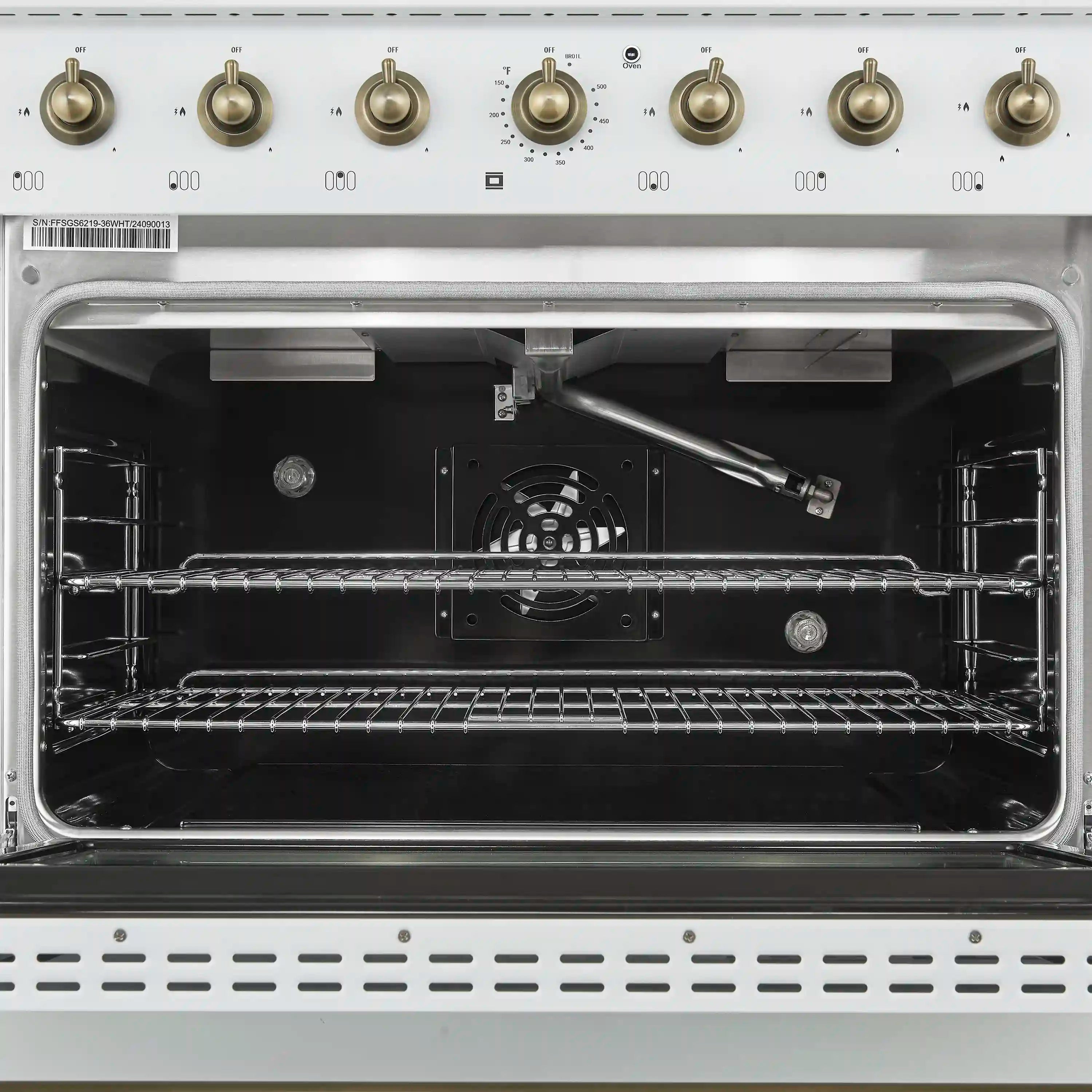Open oven cavity of a white gas range with wire racks and central fan