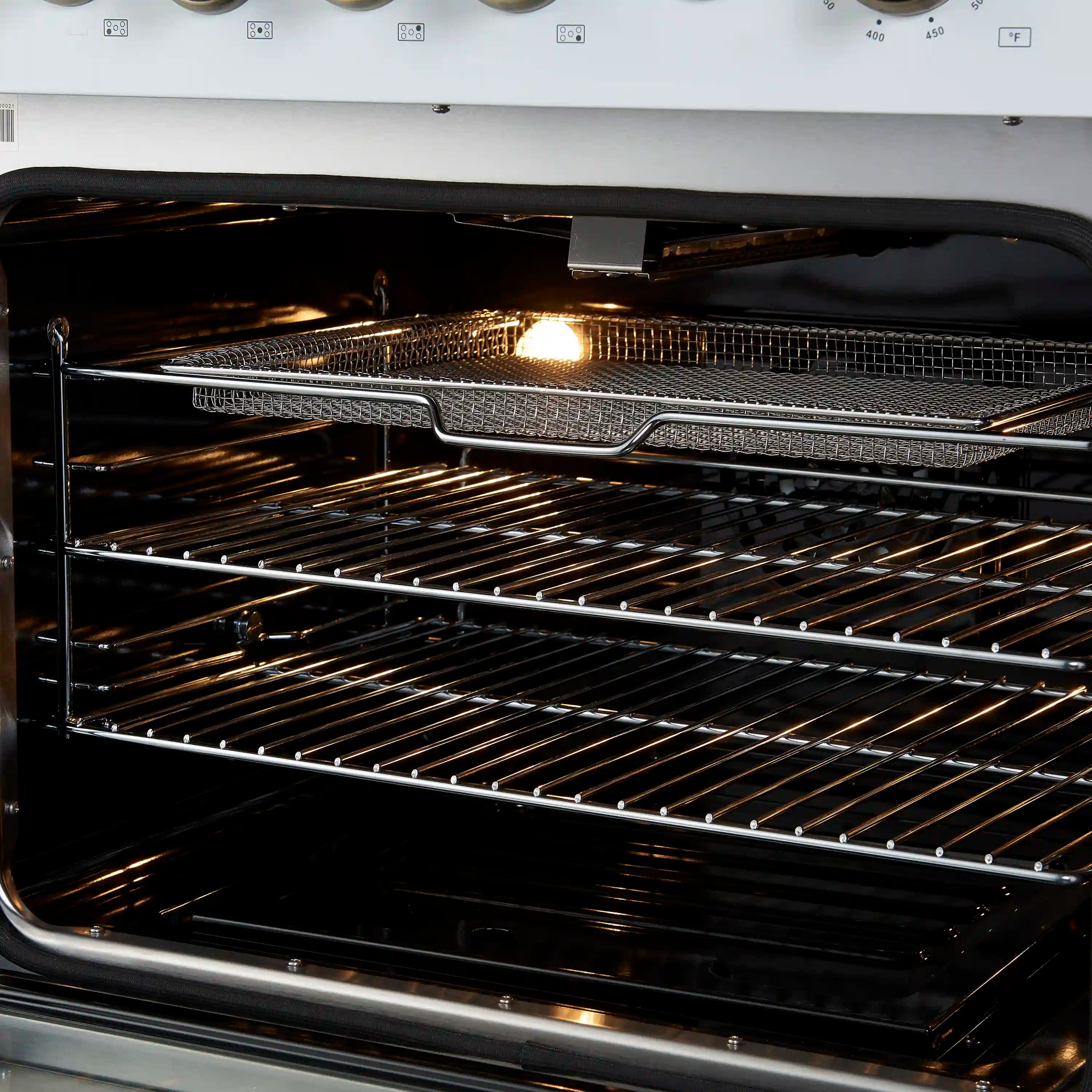 Close-up of lit gas oven convection racks with warming coils and black interior surfaces