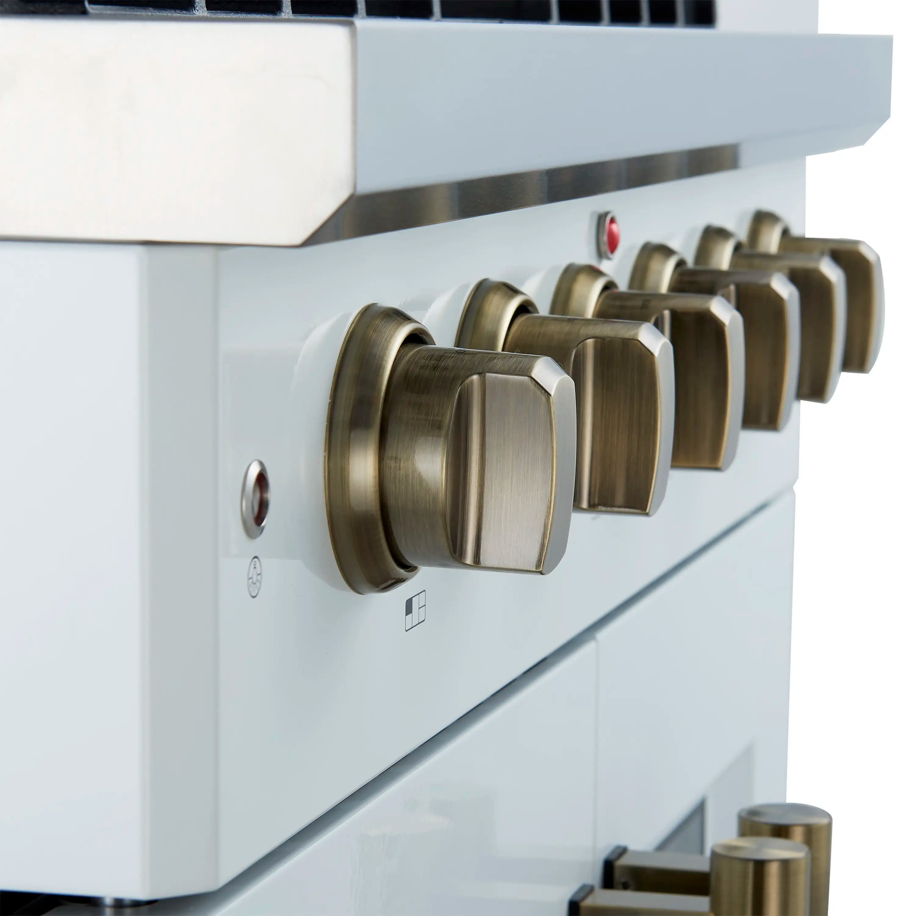 Close-up of antique brass control knobs on white gas range front panel