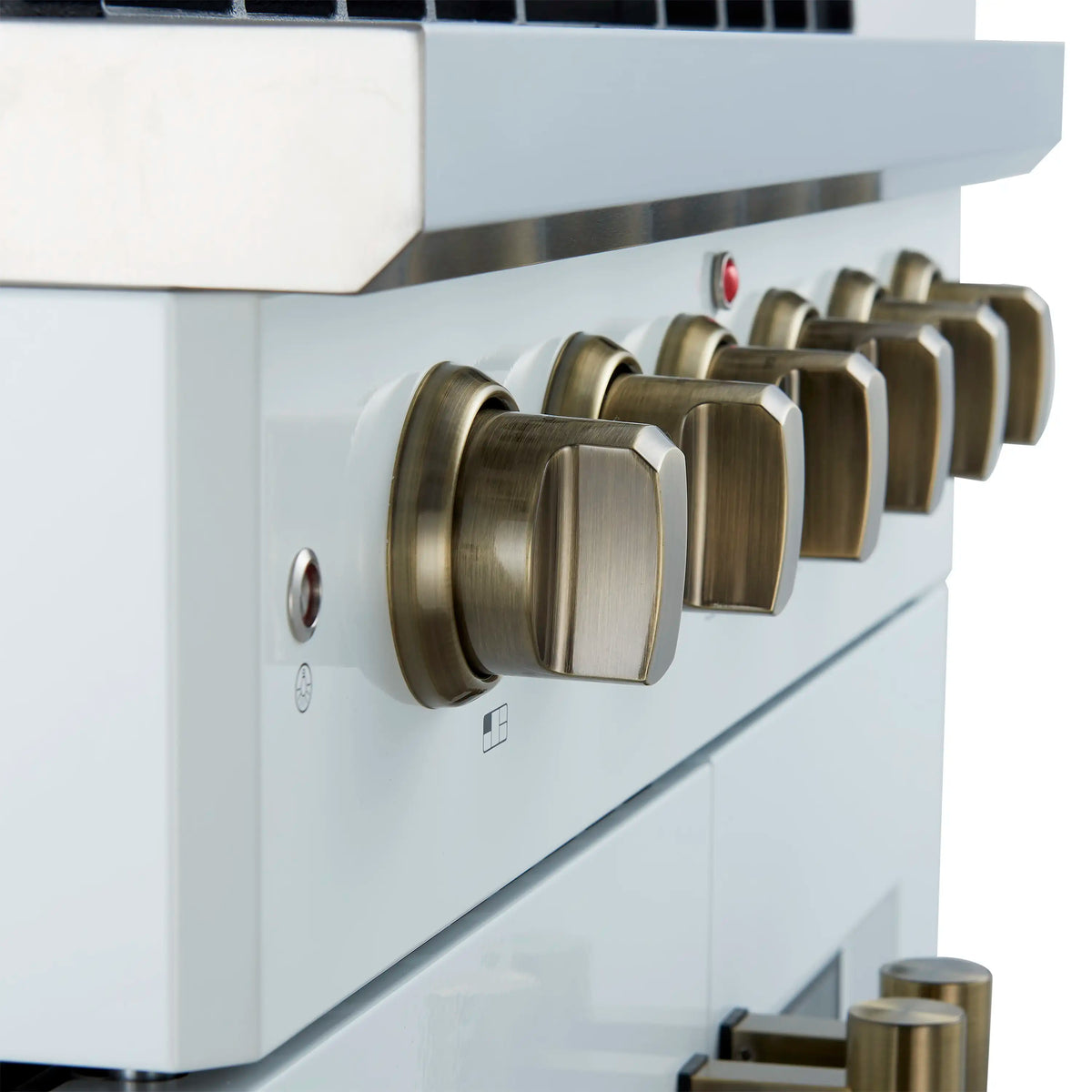 Close-up of brass-colored control knobs on a white gas range
