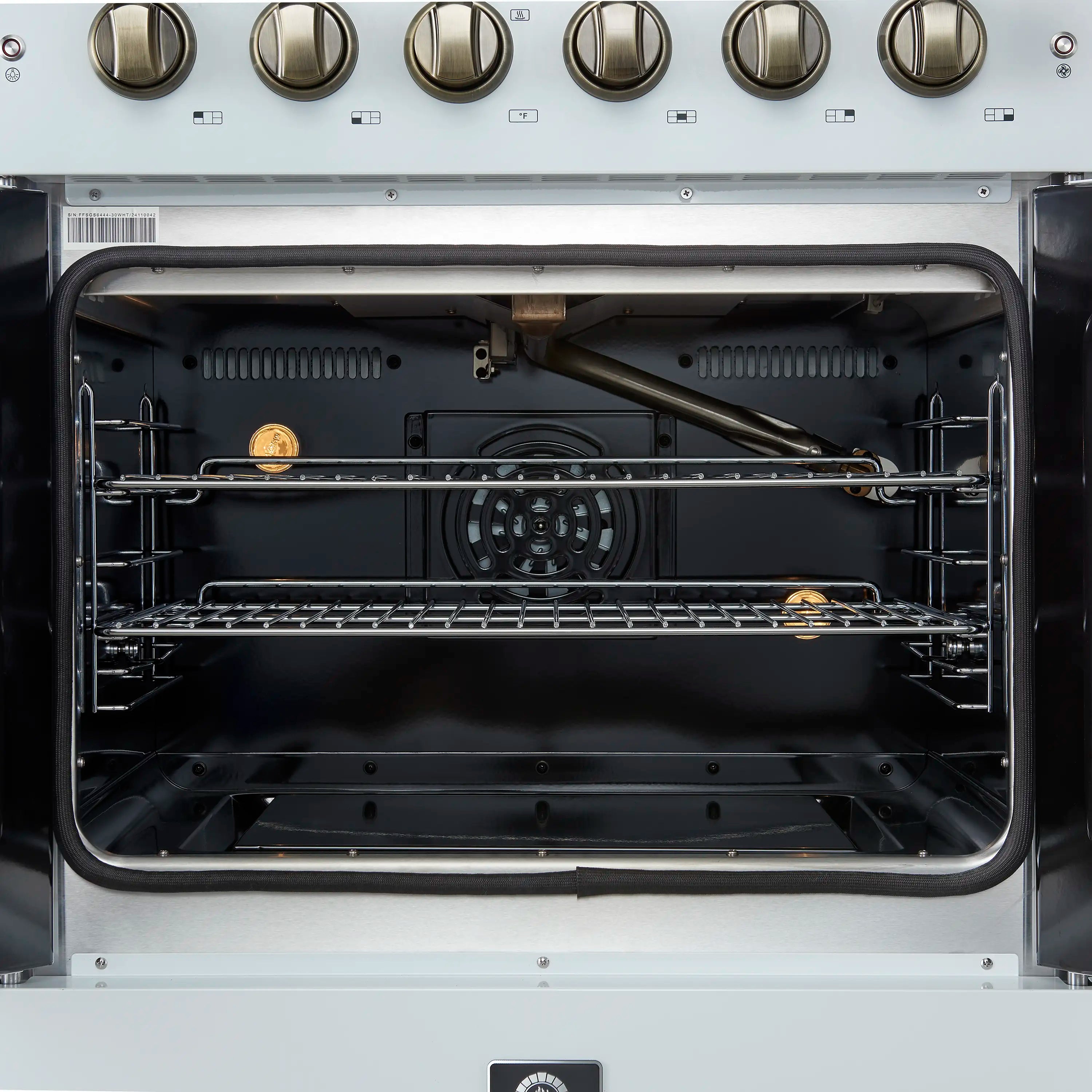 Open oven with top and bottom racks inside a black interior, gas range with brass knobs