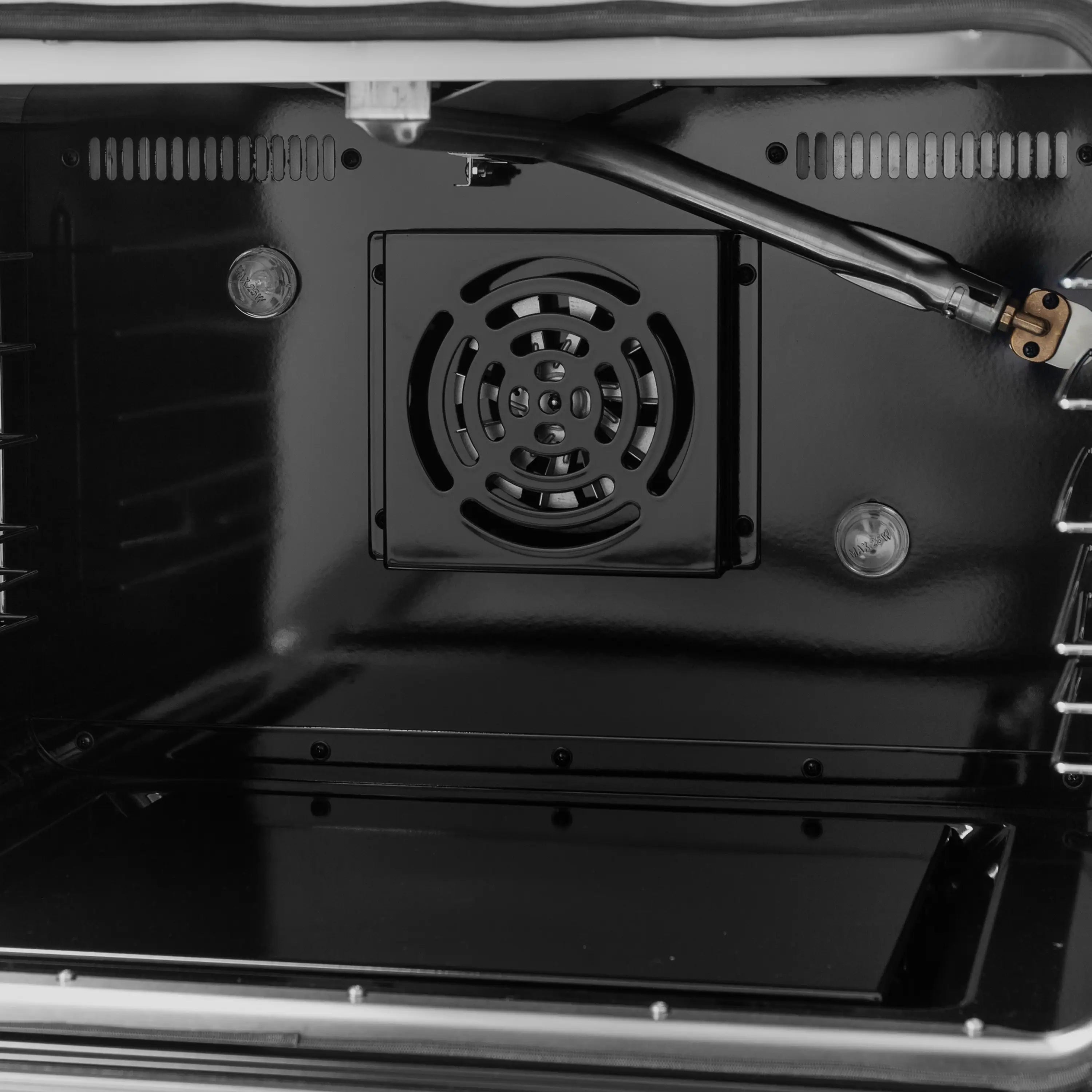 Convection oven interior with circular fan and metal back panel