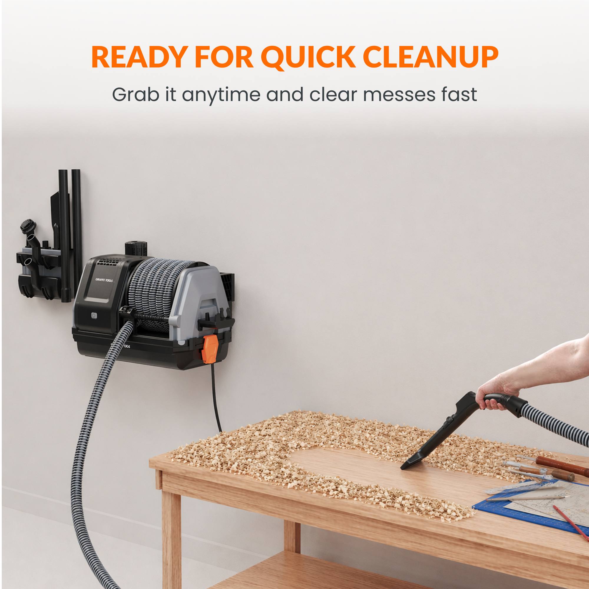 Hand-held vacuum wand with retractable hose near a tabletop cleaning nozzle