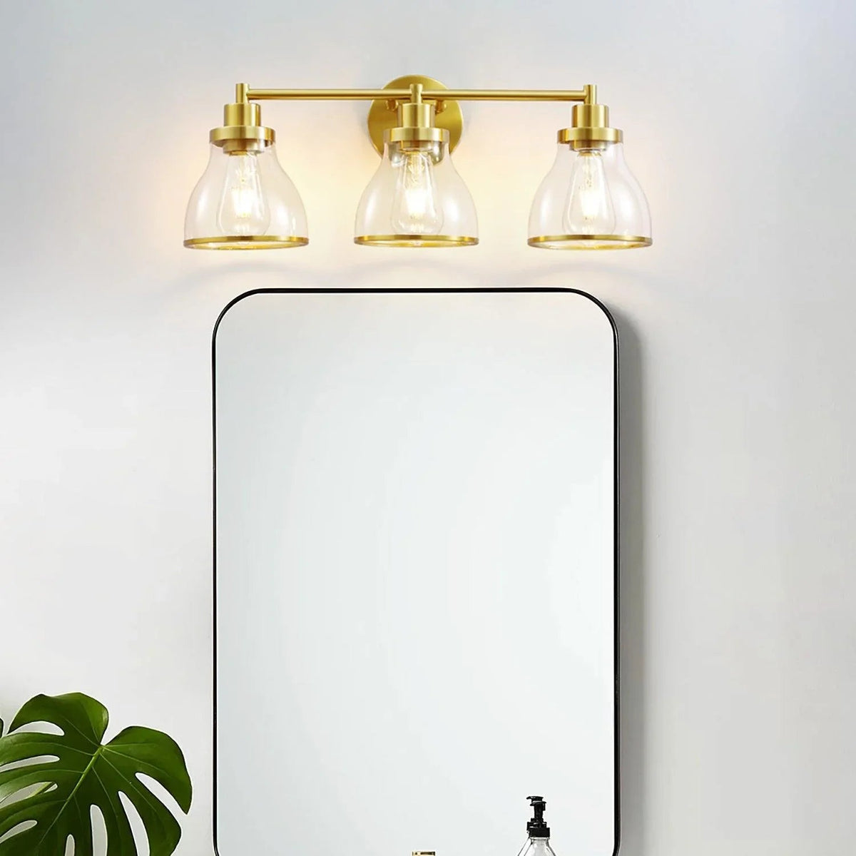 Black 3-light modern bathroom vanity light with clear glass shades and rectangular back