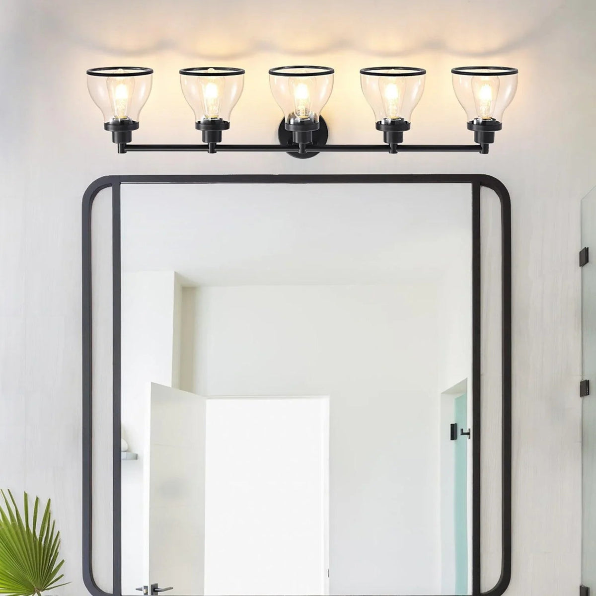 Black 5-light bathroom vanity light above mirror with clear glass shades