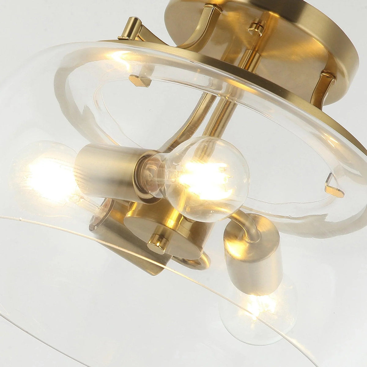 Brass gold semi-flush ceiling light angled view with clear glass dome and three bulbs