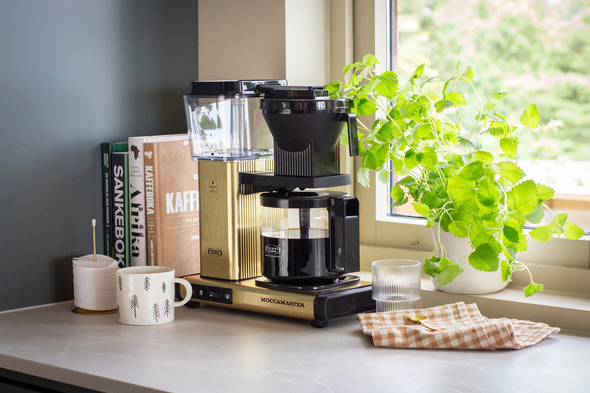Moccamaster coffee maker in brushed gold with glass carafe and black funnel