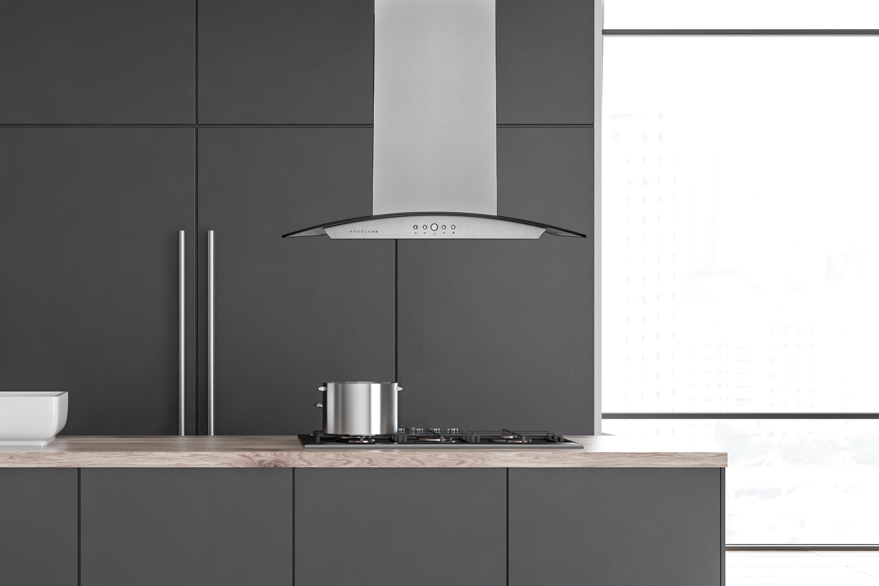 Stainless steel island range hood above kitchen cooktop with chimney stack