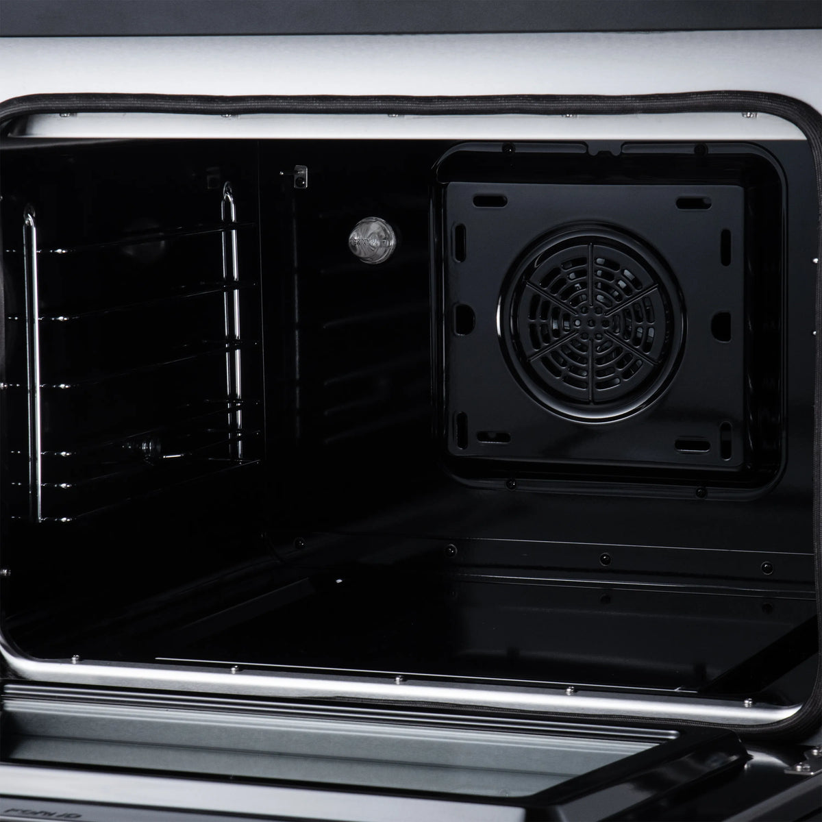 Black oven interior with fan cover, rack rails, and removable broiler pan