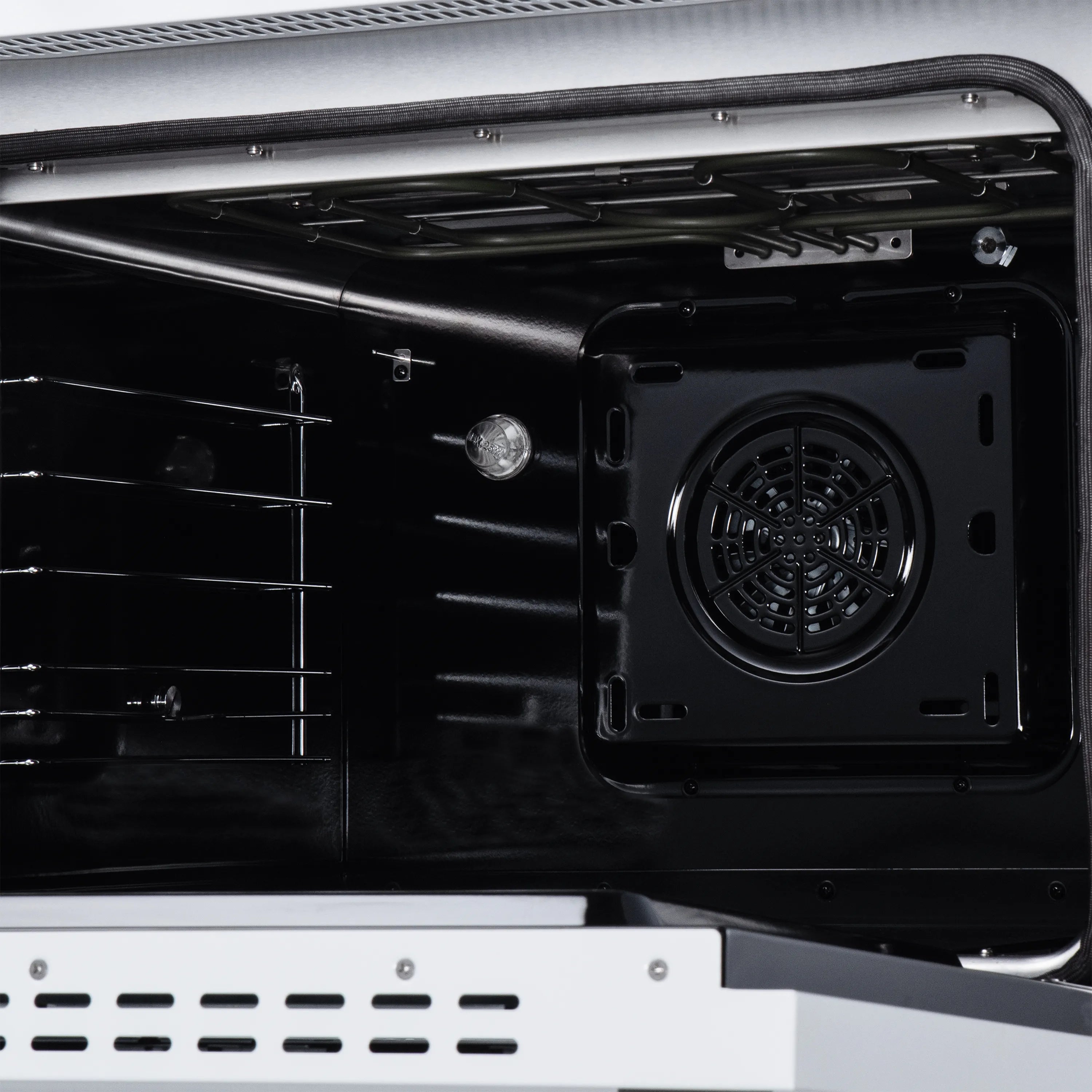 Open black oven cavity with rear fan and heating elements, induction range