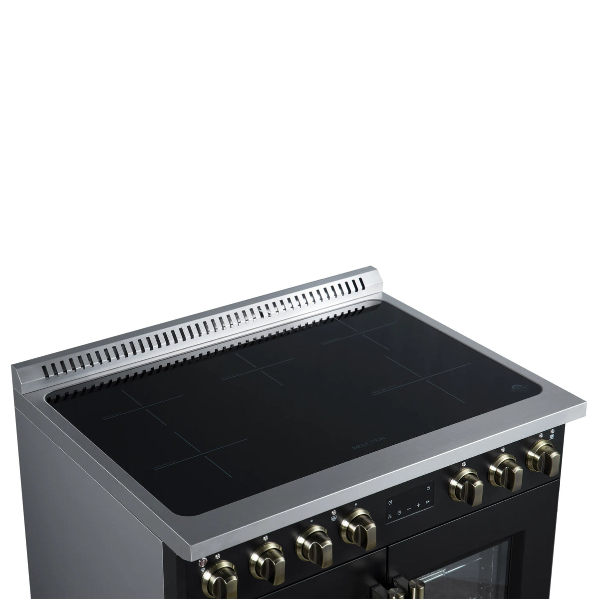 Black induction cooktop with slotted vent rail and brass control knobs