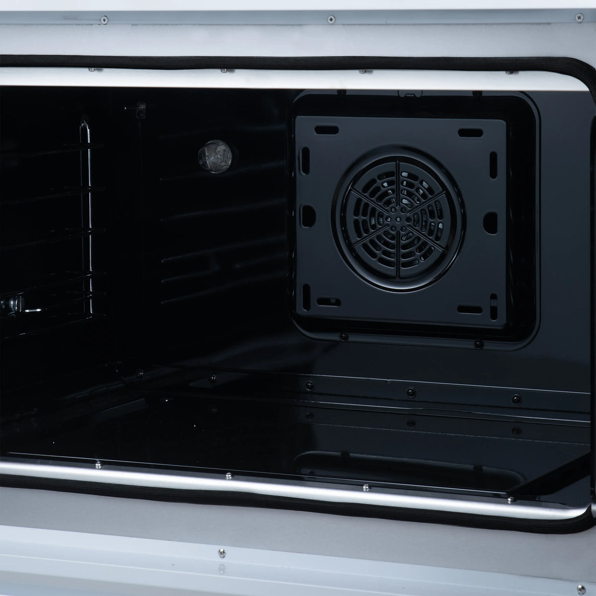 Induction range oven cavity with fan cover and dark interior racks