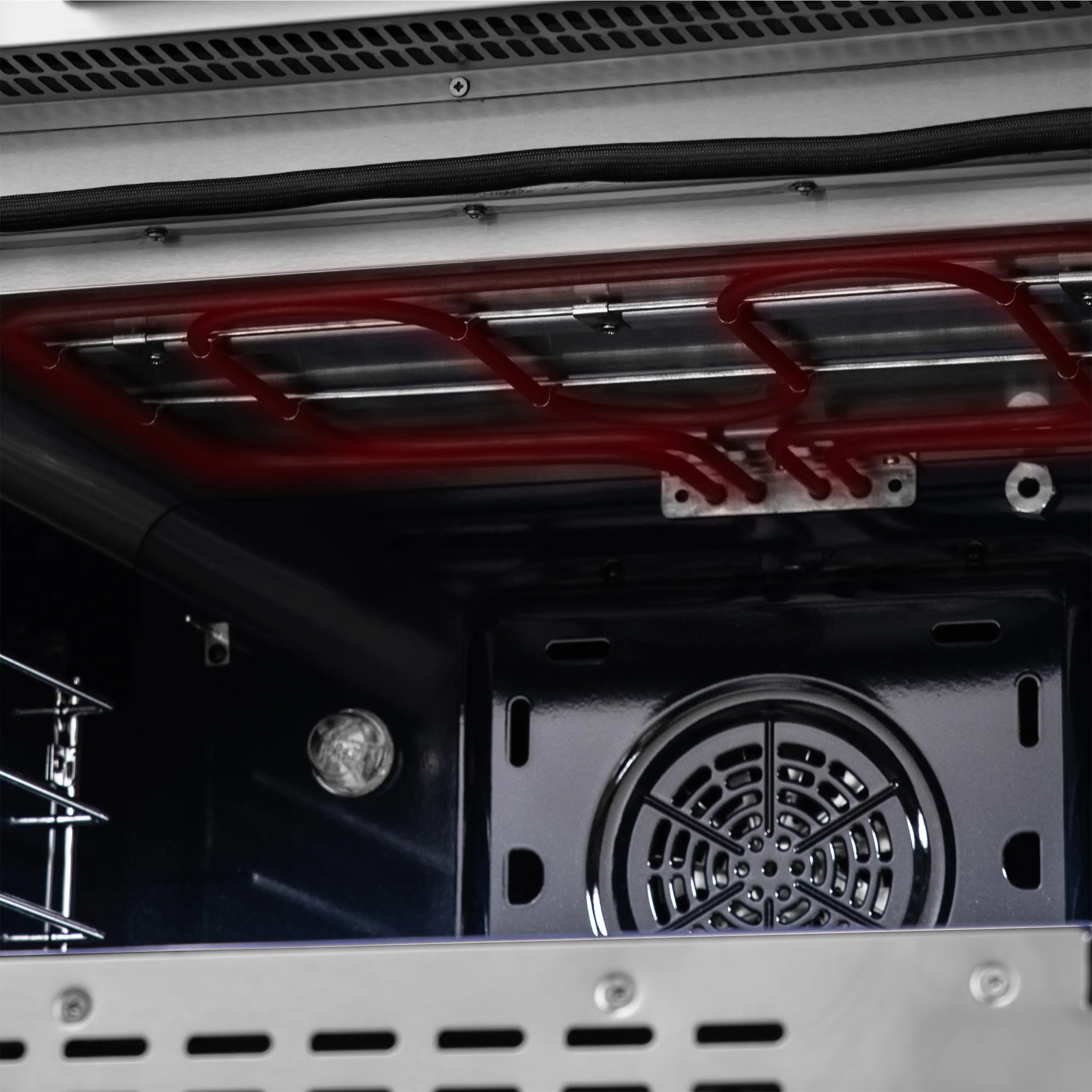 Air fryer oven interior with red heating element and circular fan outlet