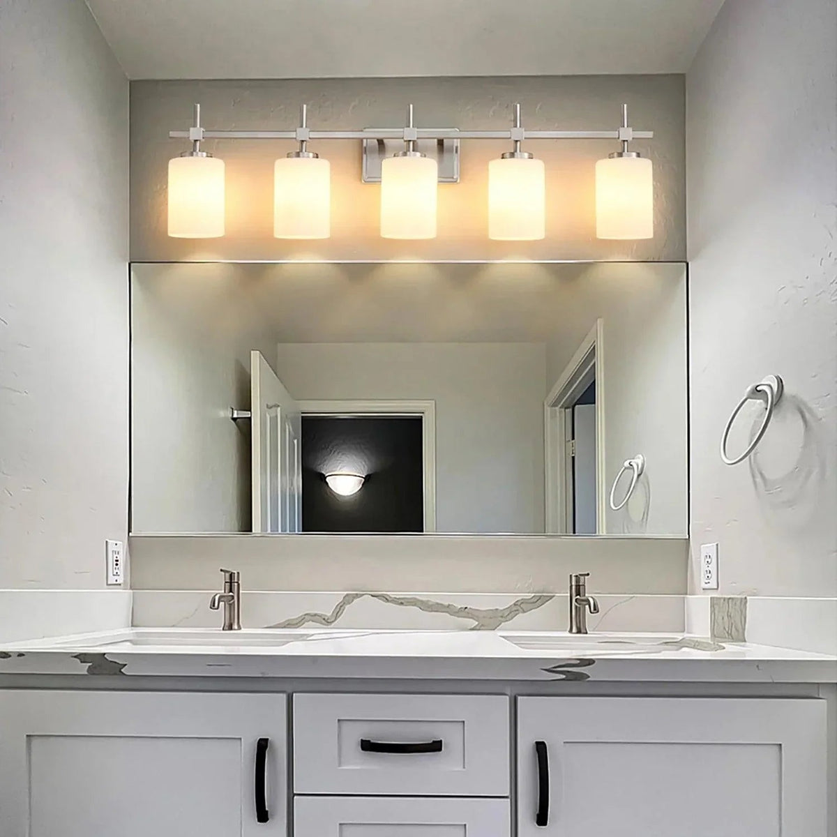 Brush nickel 5-light bathroom vanity light with frosted glass shades mounted above mirror