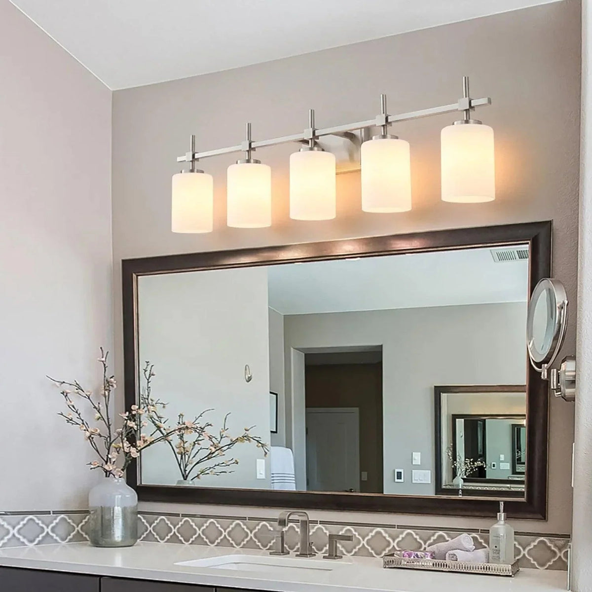 Modern 5-light bathroom vanity light with frosted glass shades above mirror