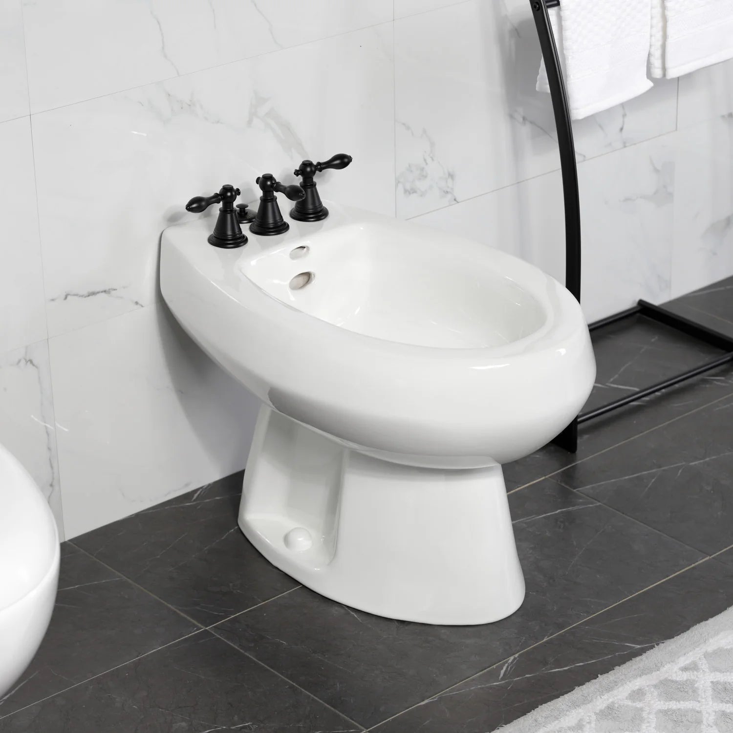 White bidet toilet with matte black spreader faucet and mounted handle knobs