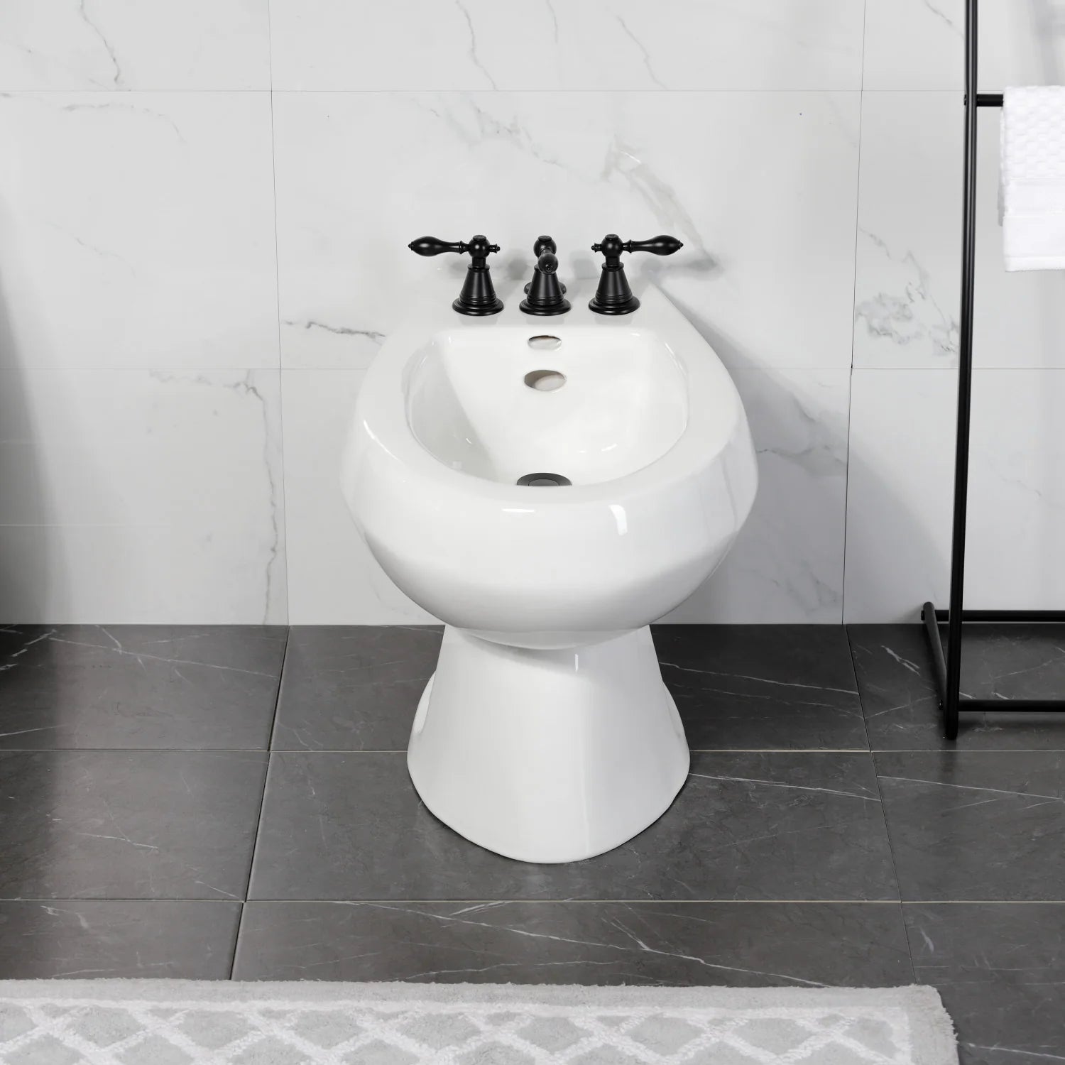 White bidet toilet with matte black three-handle faucet and drain openings