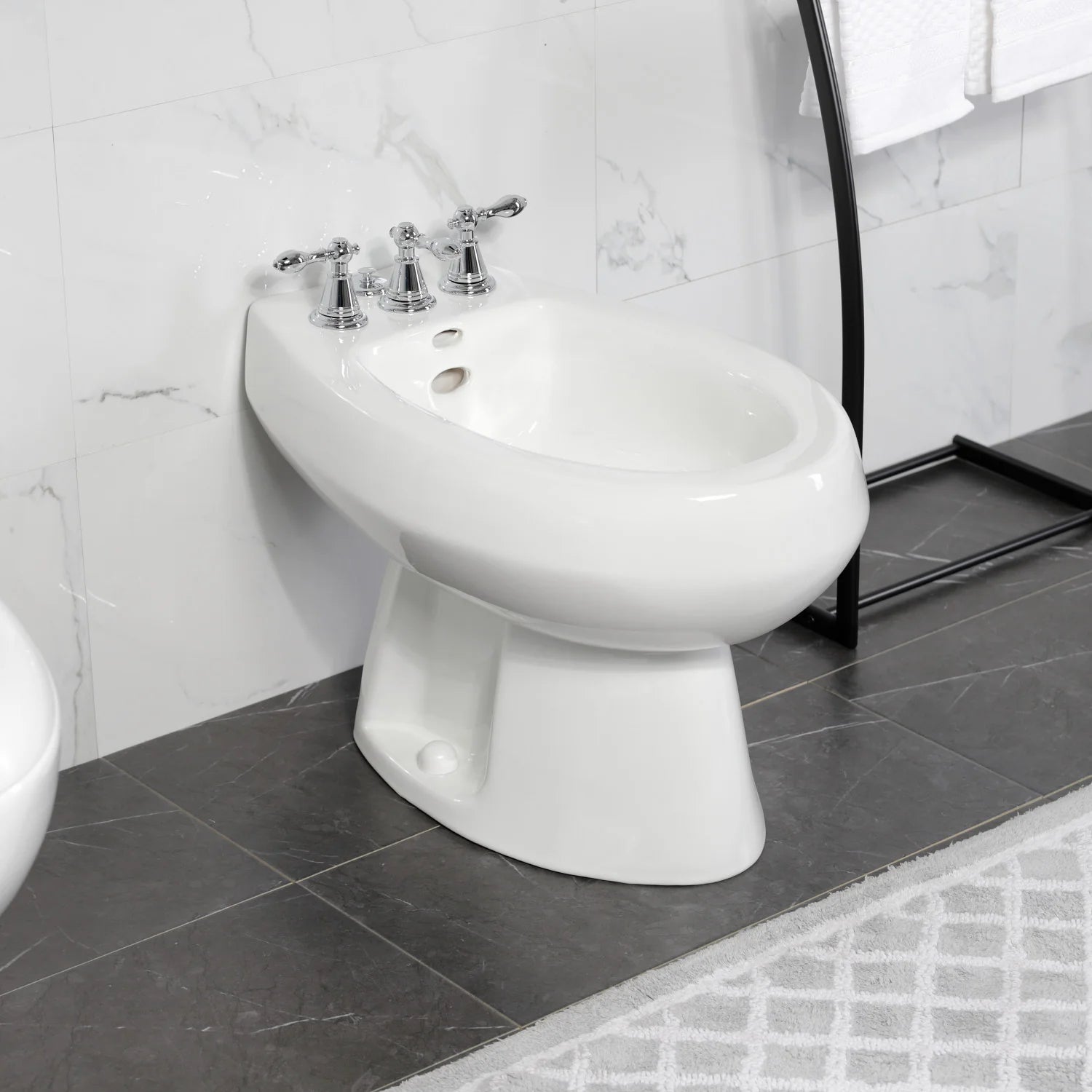 Polished chrome Victorian three-handle bidet faucet mounted on white bidet