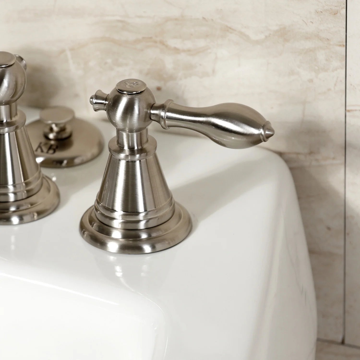 Brushed nickel Victorian bidet faucet with ornate lever handle and spout.