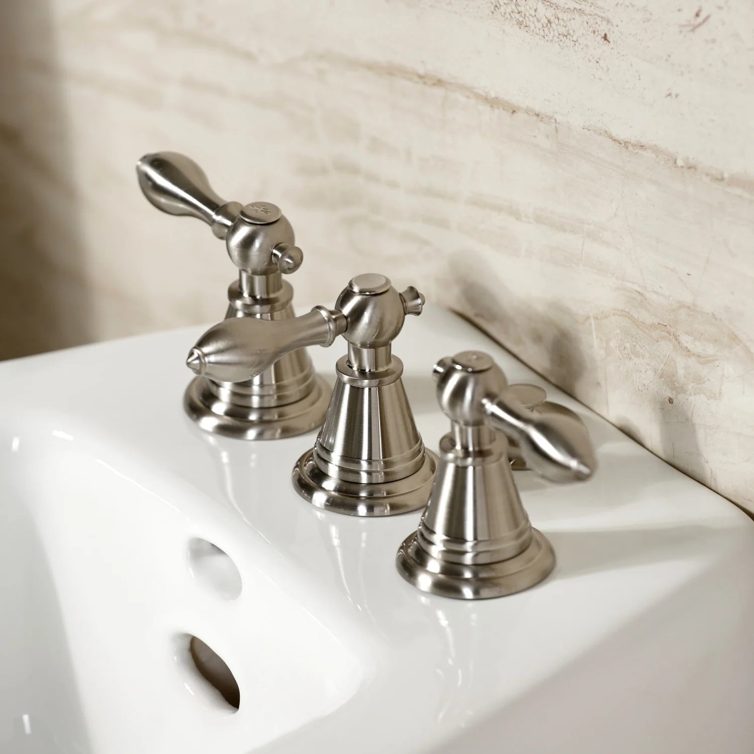 Brushed nickel Victorian three-handle bidet faucet with cross-handle levers.