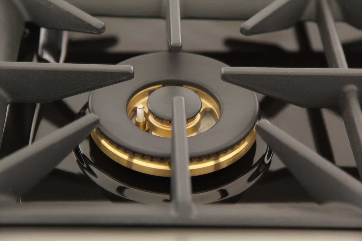 Gas range burner with brass ring center and black cast grates, stainless frame