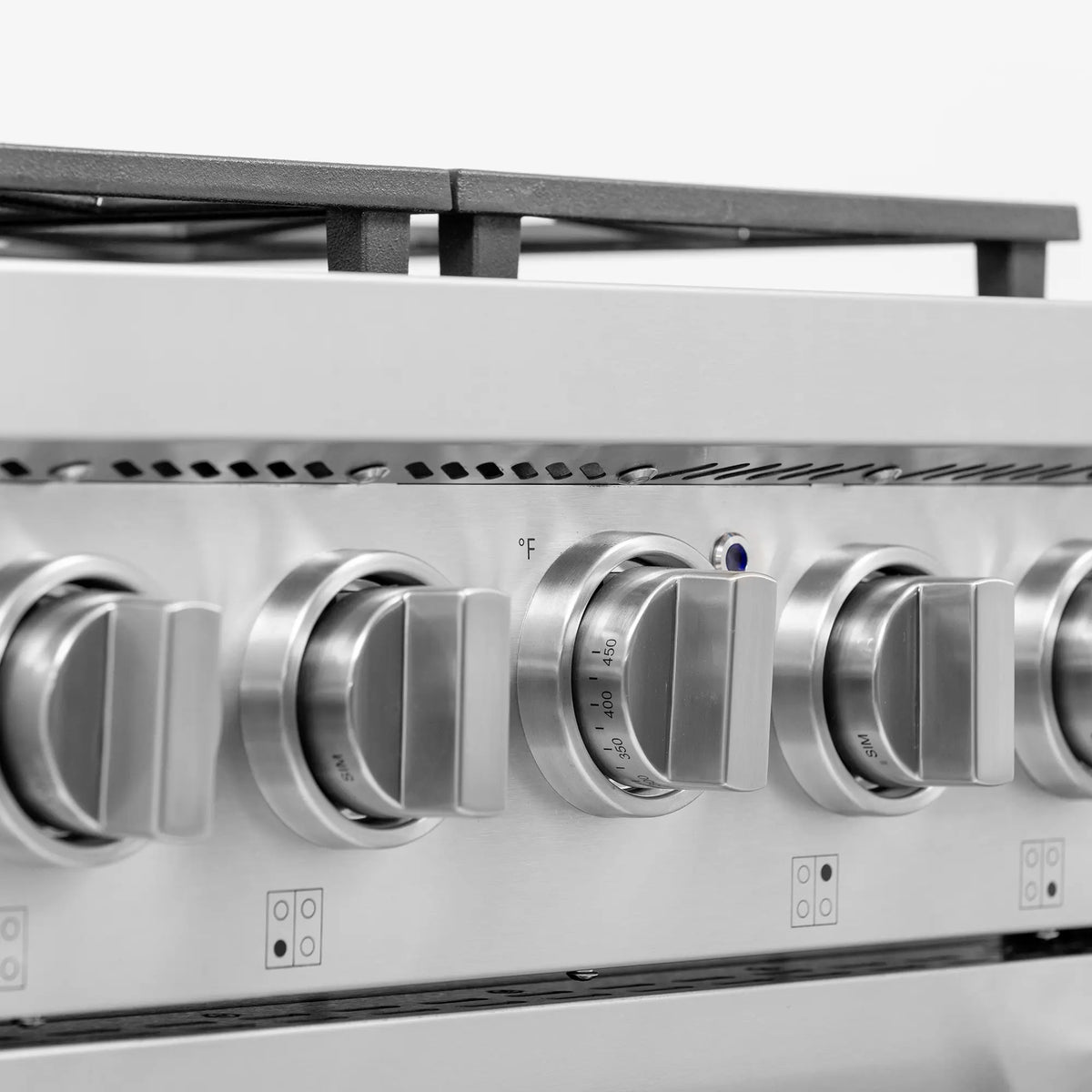 Stainless steel gas range control knobs row with temperature markings