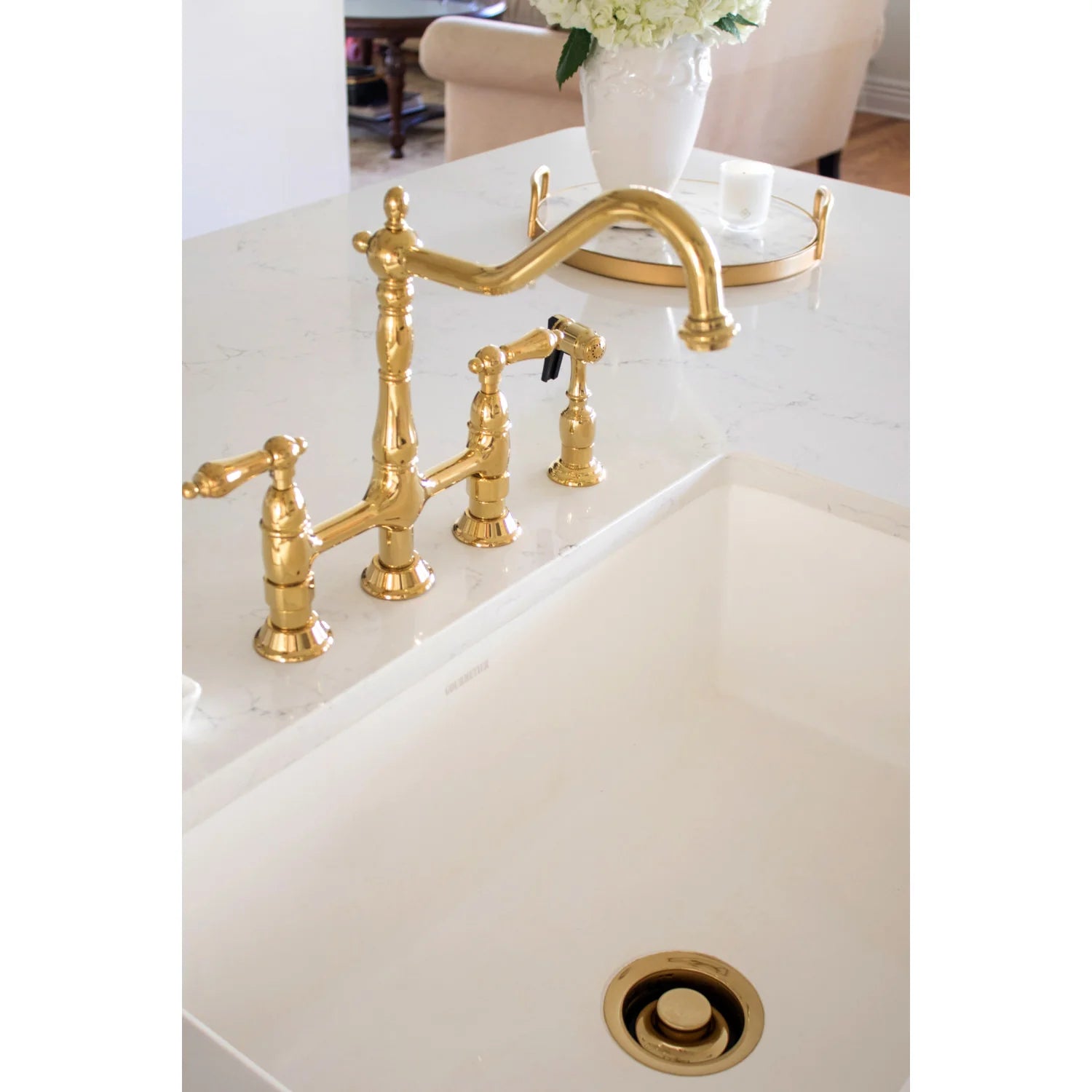 Polished brass deck-mounted bridge faucet with side sprayer and handles