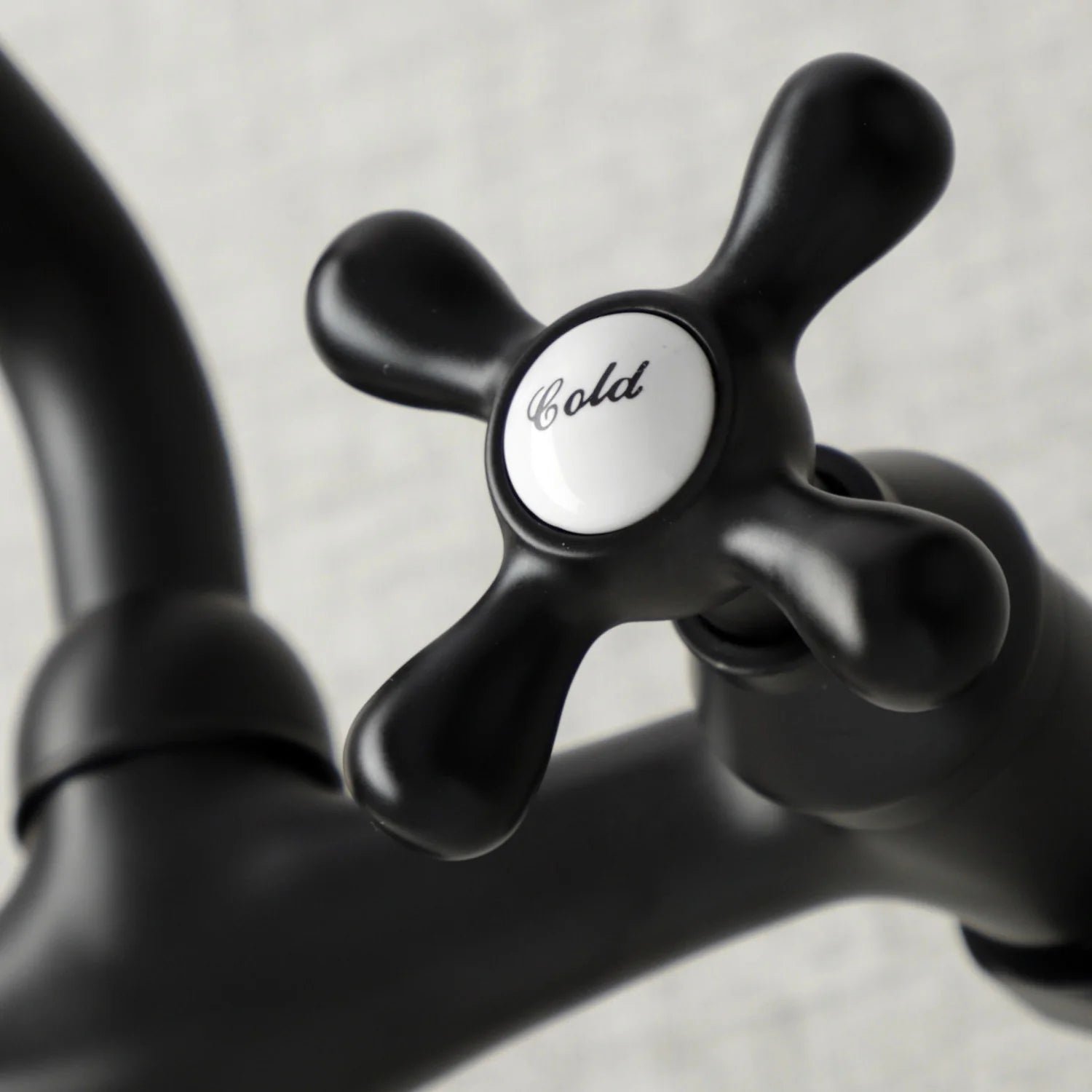 Matte black dual-handle faucet knob with 'hot' label and lever-style stems